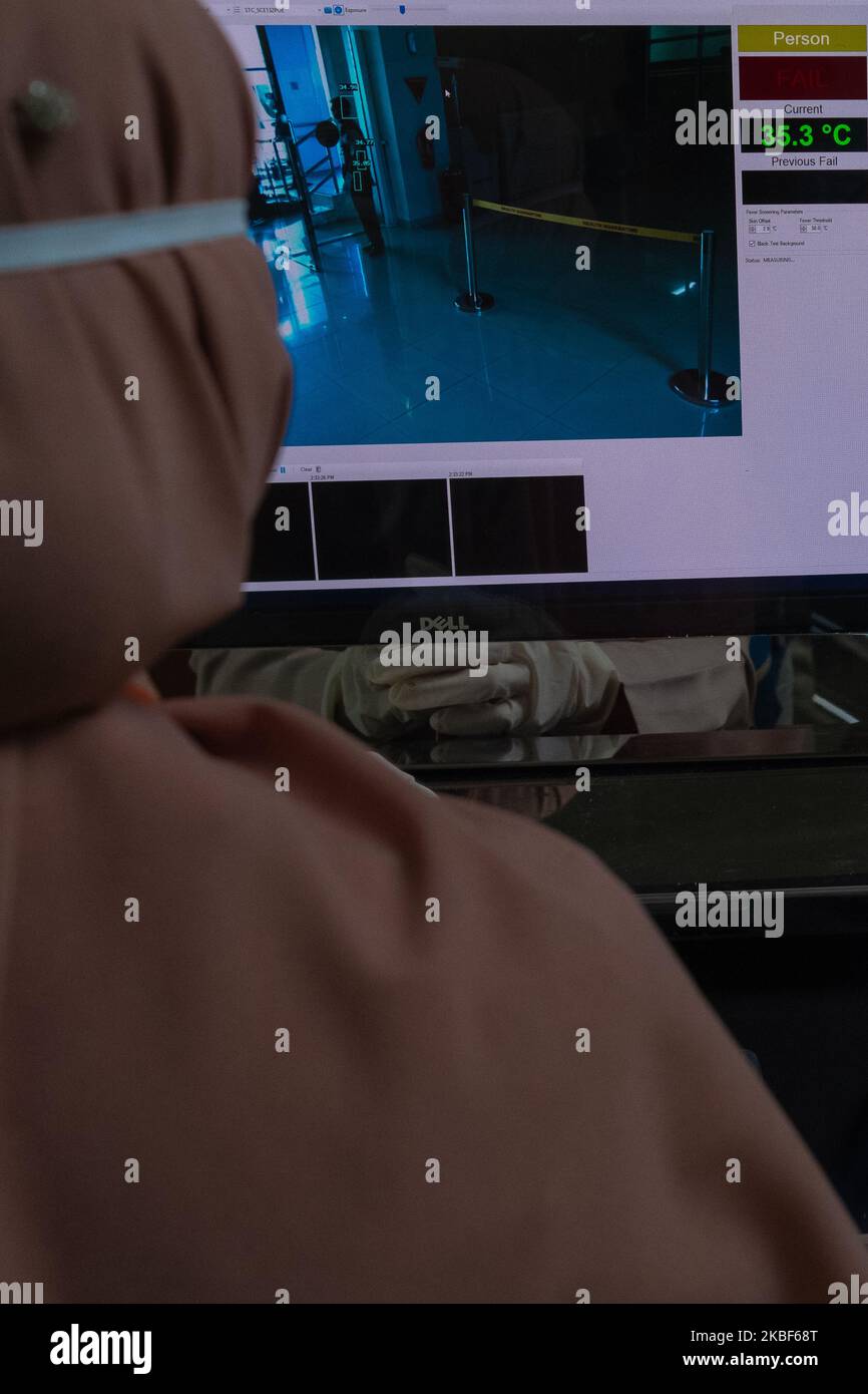 A health worker monitors a thermal scanner as passengers arrive at Sultan Syarif Kasim II airport on January 23, 2020 in Pekanbaru, Indonesia. A new virus that has killed nine people, infected hundreds and already reached the United States could mutate and spread, China warned January 21, as authorities scrambled to contain the disease during the Lunar New Year travel season. (Photo by Afrianto Silalahi/NurPhoto) Stock Photo