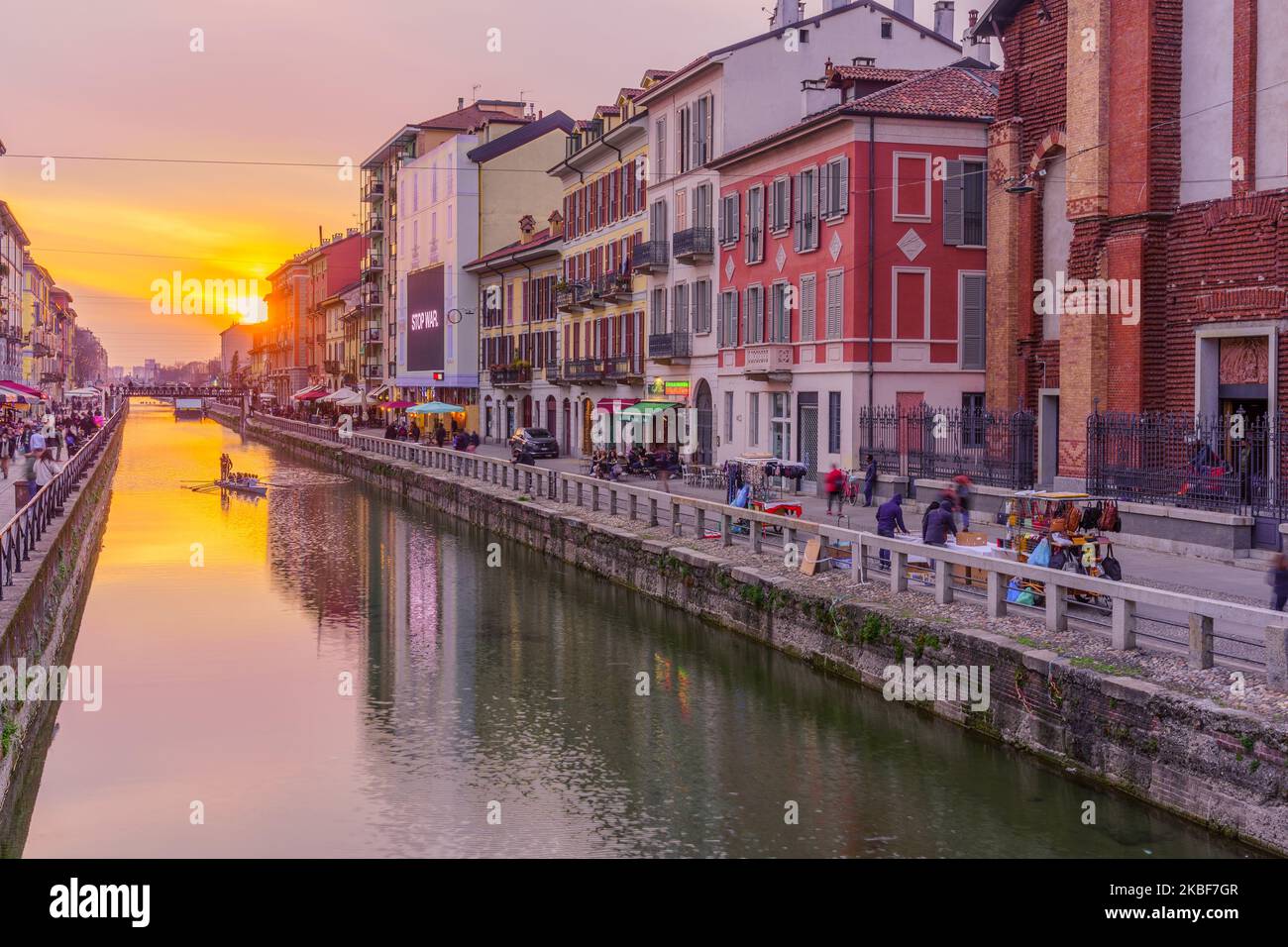 Milan, Italy - March 02, 2022: Sunset view of the Naviglio Grande canal, with locals and visitors, in Navigli, Milan, Lombardy, Northern Italy Stock Photo