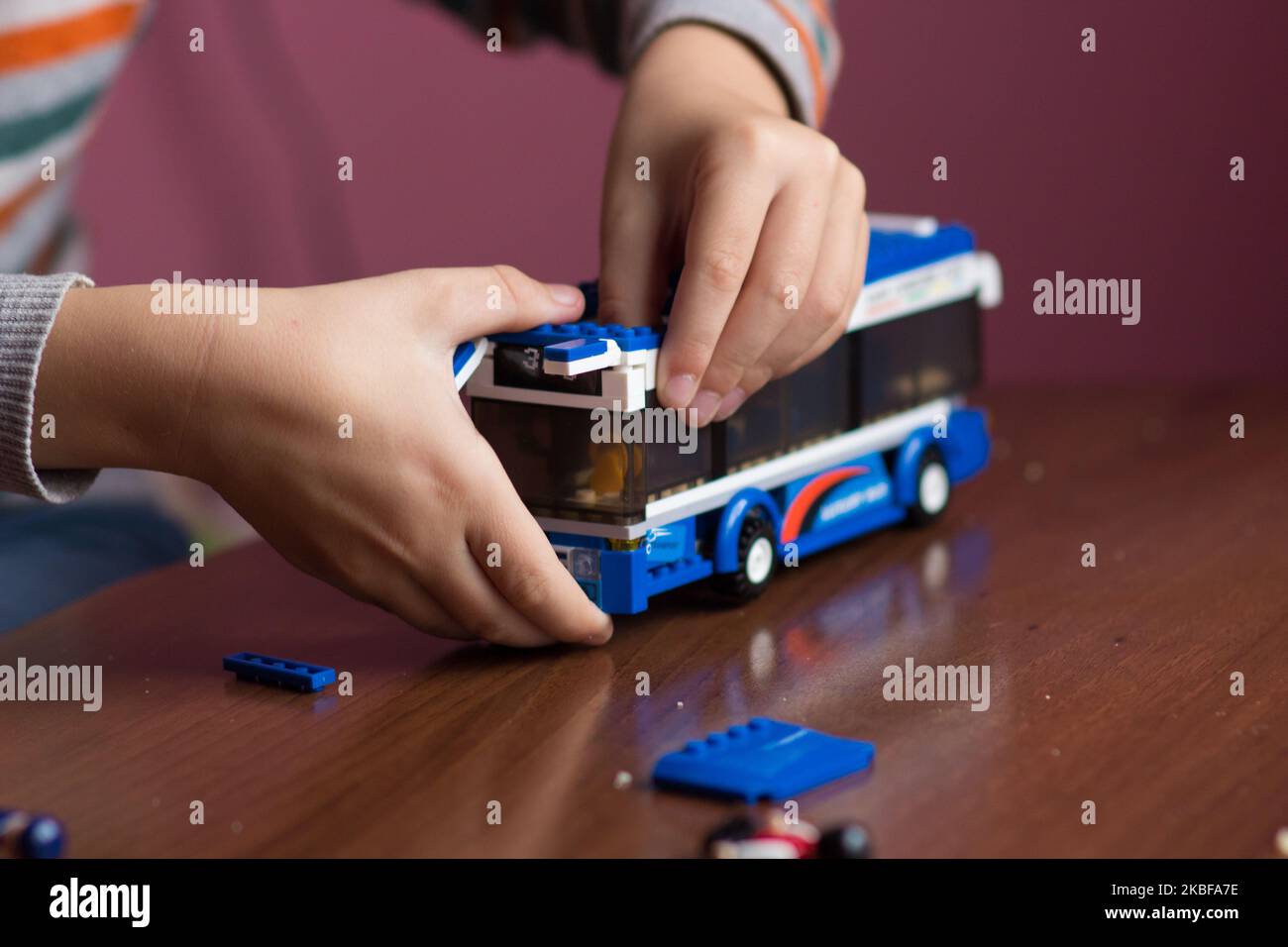 Boy's hand collect designer on toy bus bus Stock Photo
