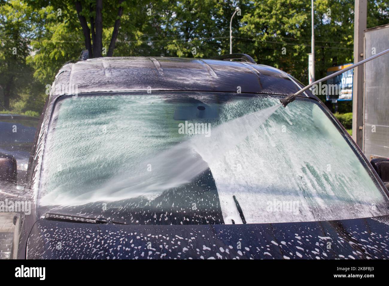 washing car windshield in car washes with high pressure water with foam