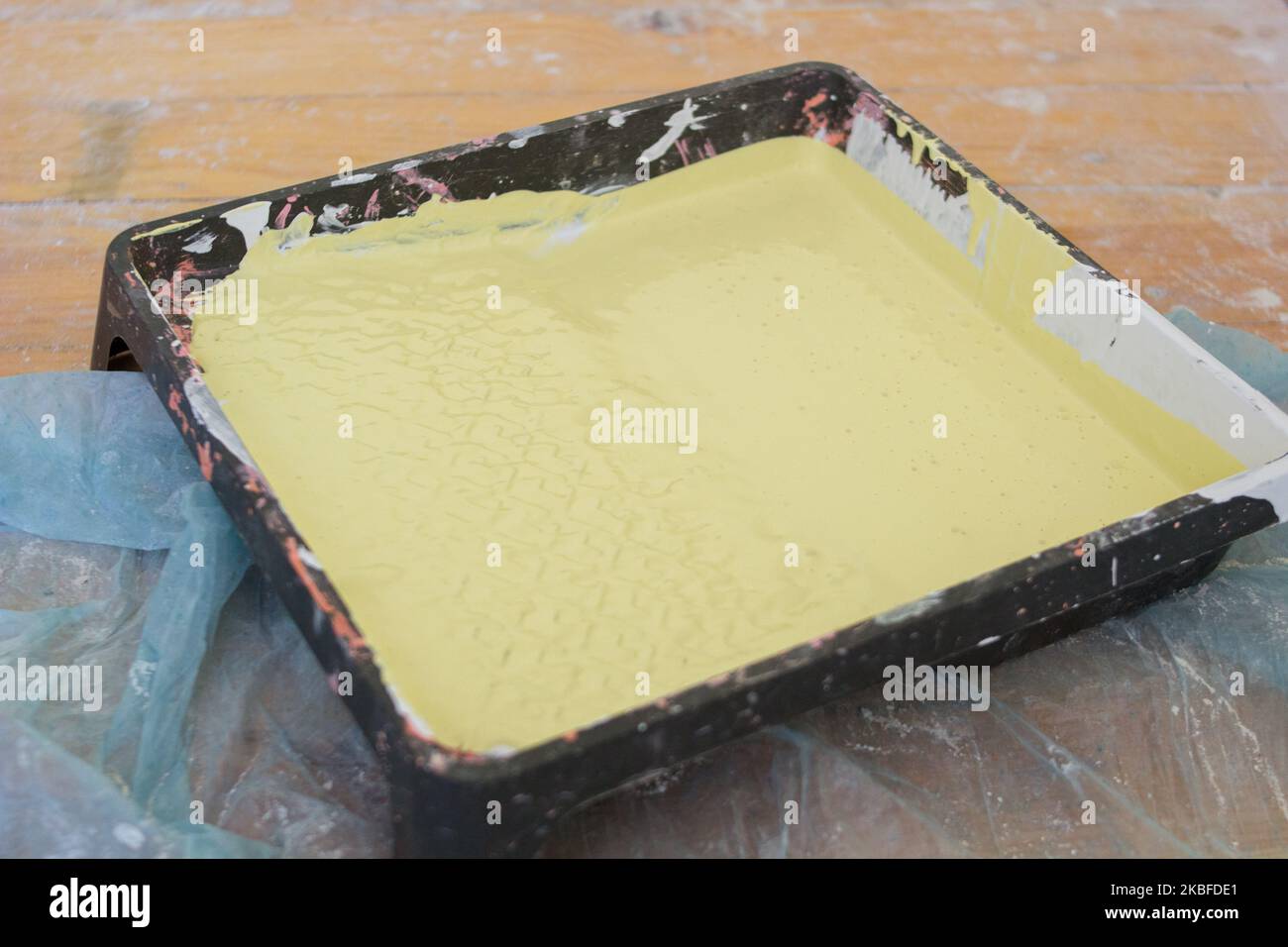 on the floor with yellow paint tray for painting walls Stock Photo
