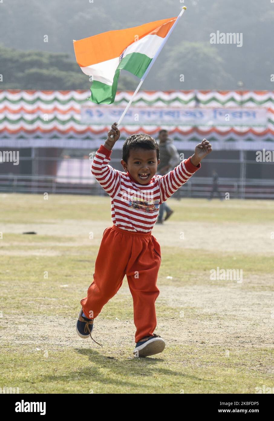 A boy runs holding an Indian Flag, during 71st Republic Day