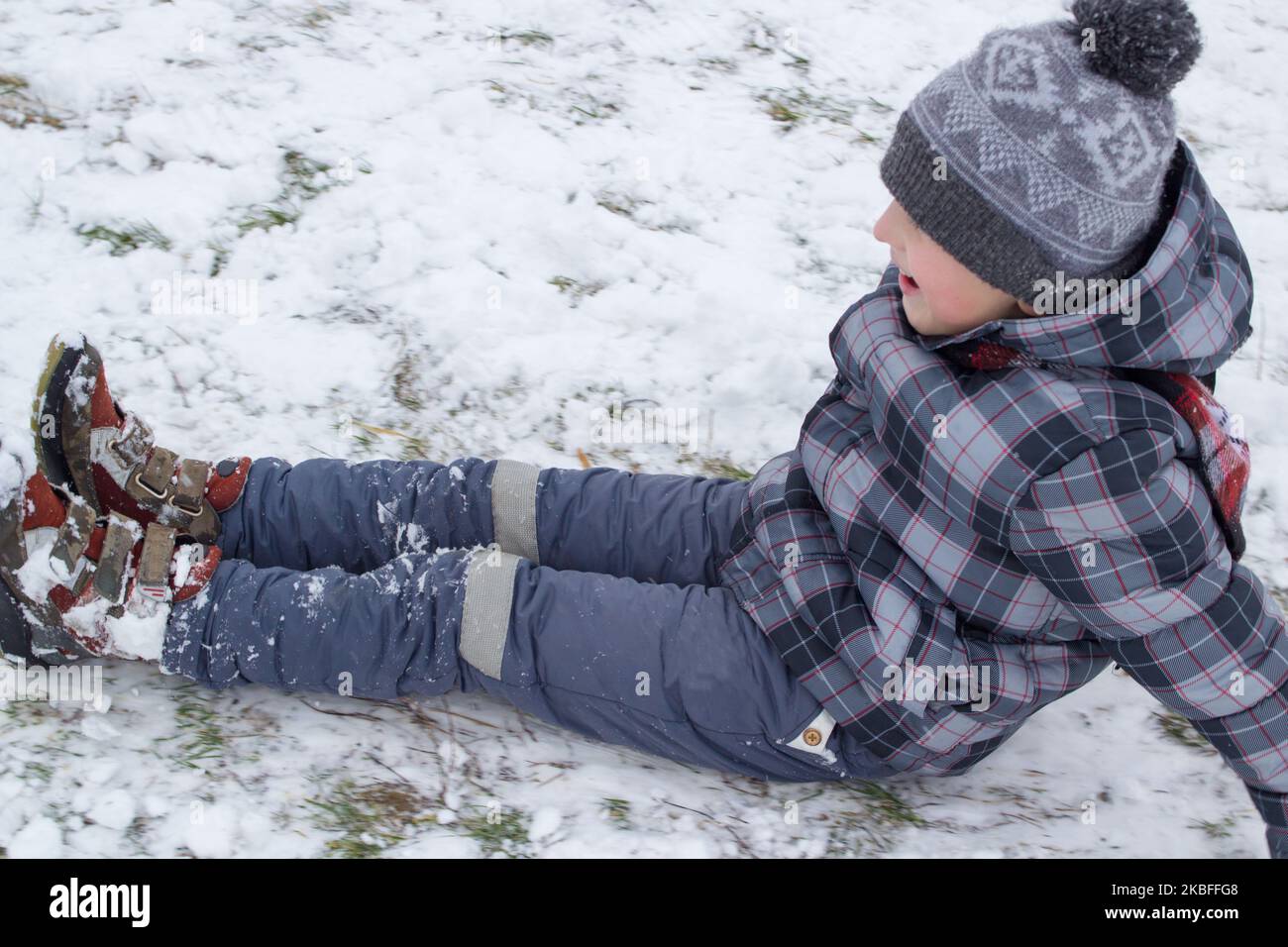 One boy was sitting on white snow and riding Stock Photo