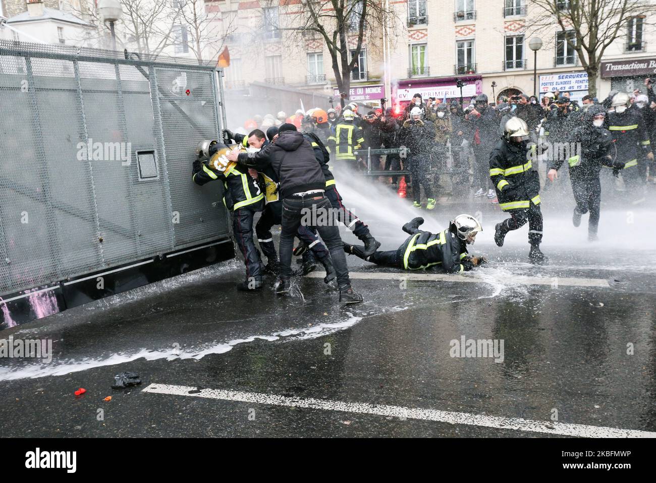 Firefighters try to open a path in a riot barricade and were repelled by water canons during a demonstration to protest against French government's plan to overhaul the country's retirement system in Paris, on January 28, 2020. (Photo by Michel Stoupak/NurPhoto) Stock Photo