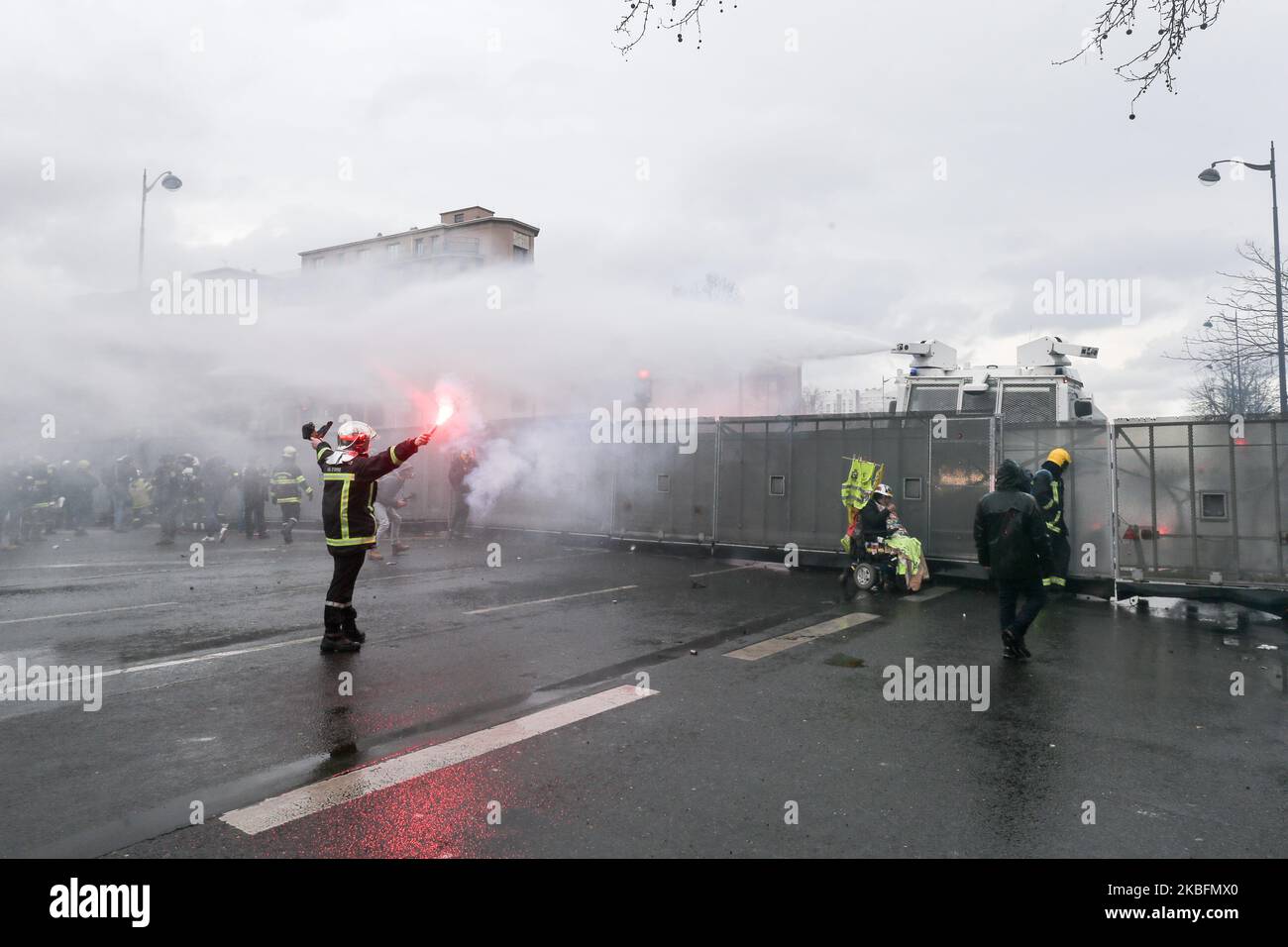 A firefighter stands in front of water canons during a demonstration to protest against French government's plan to overhaul the country's retirement system in Paris, on January 28, 2020. (Photo by Michel Stoupak/NurPhoto) Stock Photo