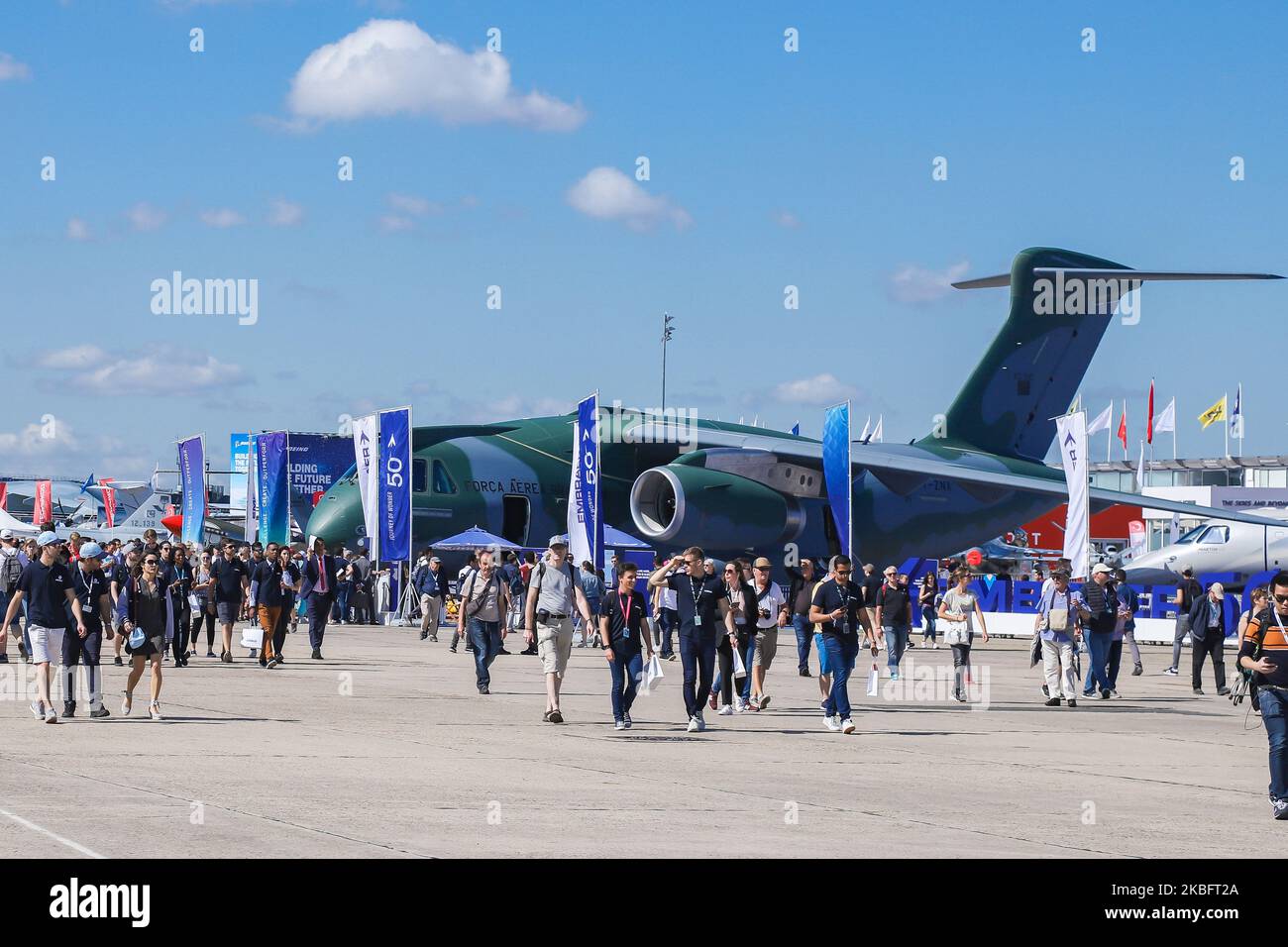Crowd of visitors at the tarmac of Le Bourget Airport during Paris Air Show 2019 and the Brazilian Air Force Embraer KC-390 renamed after Boeing and Embraer deal as C-390 Millennium, the made in Brazil medium sized transport aircraft as seen on 53rd Paris Air Show Le Bourget in France on June 21, 2019. It is made by Brazilian aerospace manufacturer Embraer Defense and Security with its first flight on February 3, 2019. The military multipurpose airplane for cargo, aerialrefueling and troops can carry 26 tonnes in its fuselage and the 2x IAE V2500 jet engines. The aircraft registration is PT-ZN Stock Photo