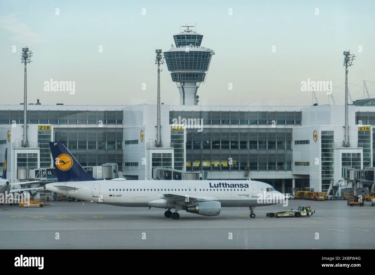 A Lufthansa Airbus A320 with registration D-AIZF in front of the terminal and control tower of Munich Airport. Early morning airplane traffic movement of Lufthansa aircraft with their logo visible on the tarmac and docked via jetbridge or air bridge at the terminal at Munich MUC EDDM international airport in Bavaria, Germany, Flughafen München in German. Deutsche Lufthansa DLH LH is the flag carrier and largest airline in Germany using Munich as one of their two hubs. Lufthansa is a Star Alliance aviation alliance member. January 26, 2020 (Photo by Nicolas Economou/NurPhoto) Stock Photo