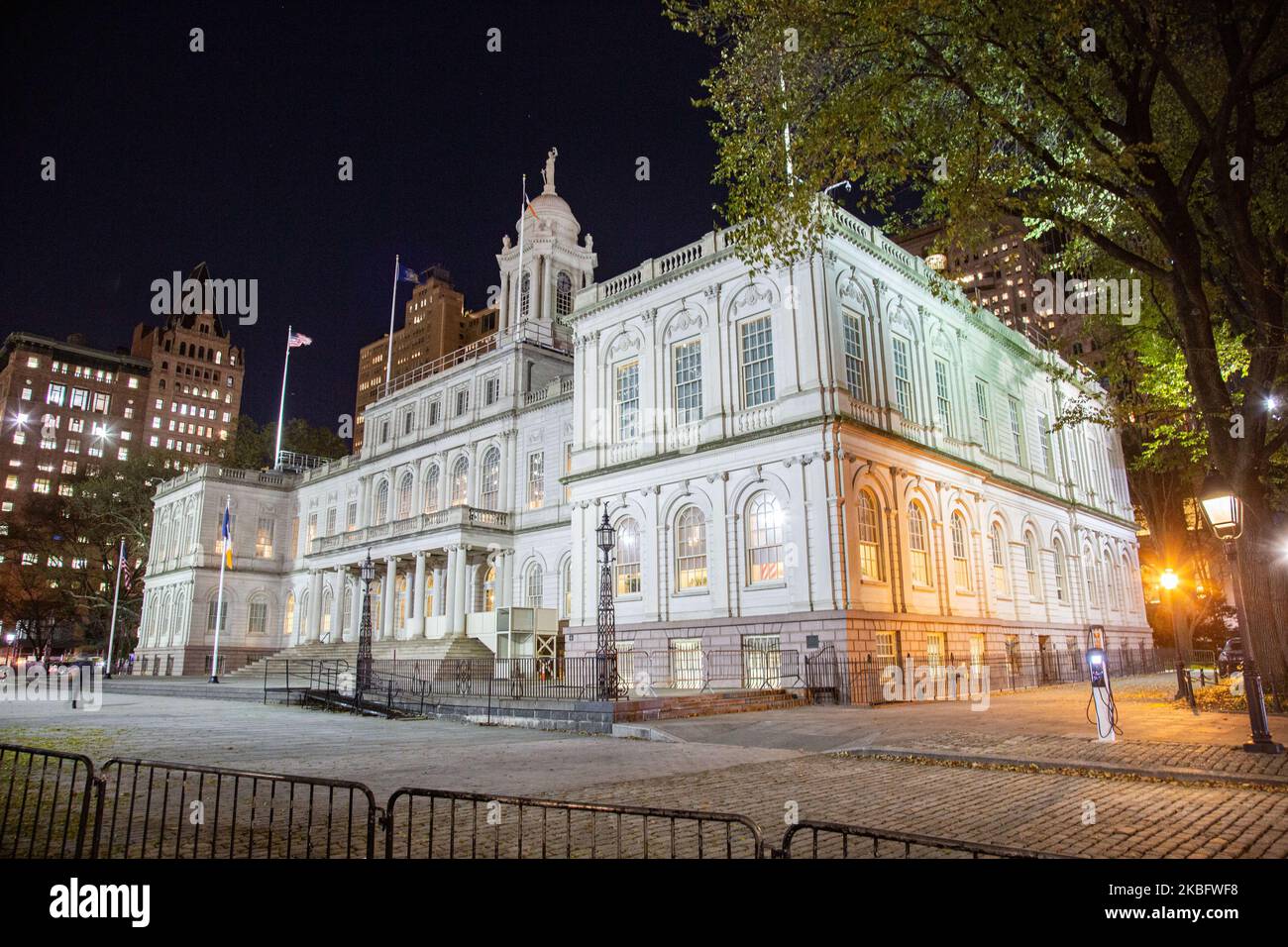 New York City Hall circa 1812 government complex, the seat of NYC government and office of the mayor, city council, located at the center of City Hall Park in the Civic Center area of Lower Manhattan, between Broadway, Park Row, and Chambers Street as seen illuminated at night. The historic building with exterior French Renaissance Revival architectural style is the oldest city hall in the United States that still houses its original governmental functions. NY, USA (Photo by Nicolas Economou/NurPhoto) Stock Photo