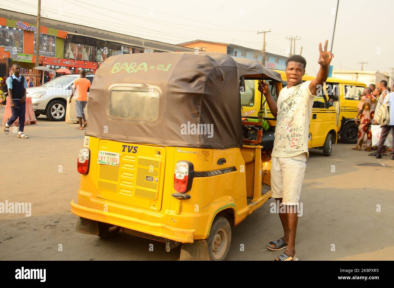 A young tricycle driver ( keke napep ) hail down for more passengers