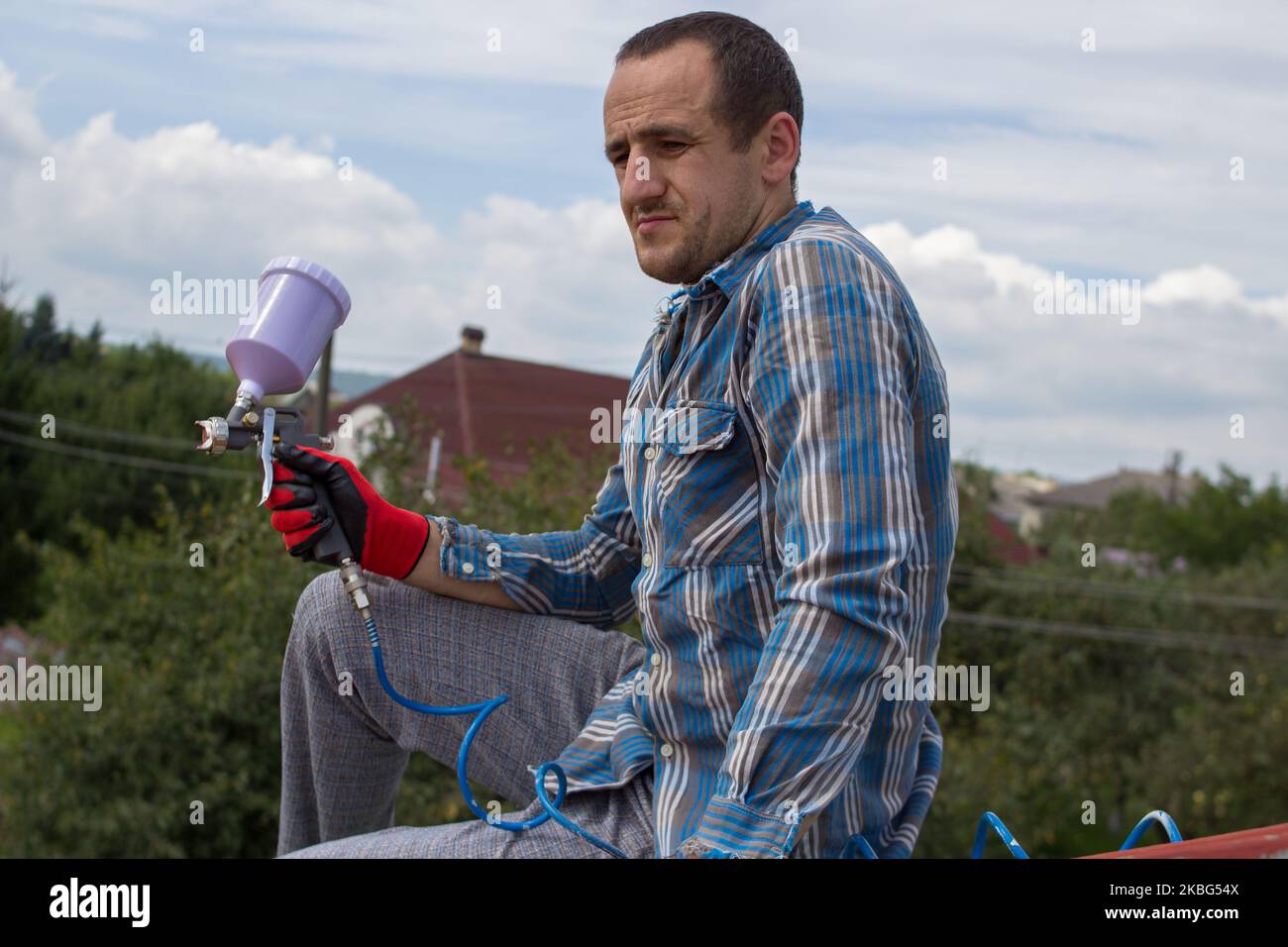 husband painter resting on the roof after painting Stock Photo