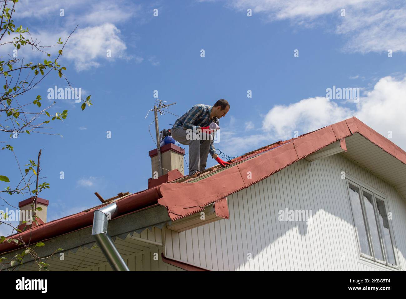 spraying spray paint on the roof of the roofer builder Stock Photo