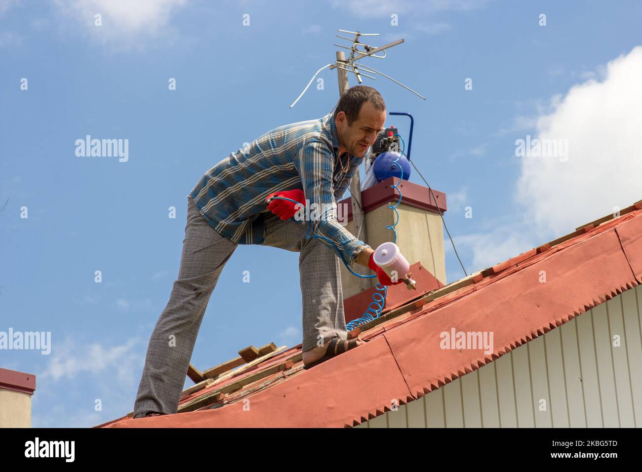 services on painting a roof at the house in a red color Stock Photo Alamy