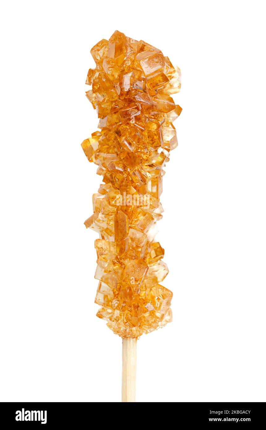 Brown rock candy, sugar candy on a wooden stick, close-up, from above, isolated, on white background. Also called rock sugar or crystal sugar. Stock Photo