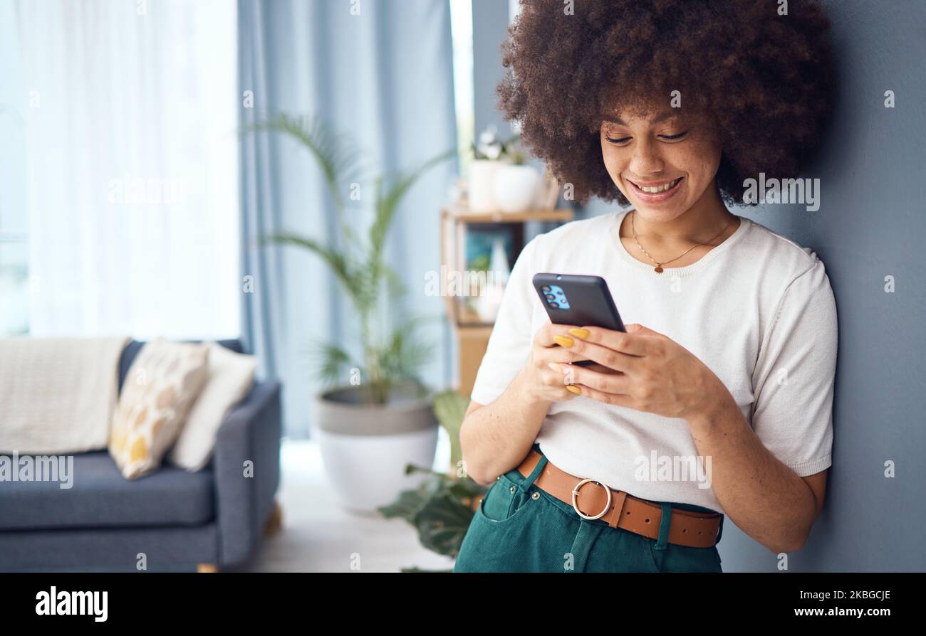 Woman, funny social media phone and happy with online dating profile notification in living room. Young smile female with afro relax at home Stock Photo