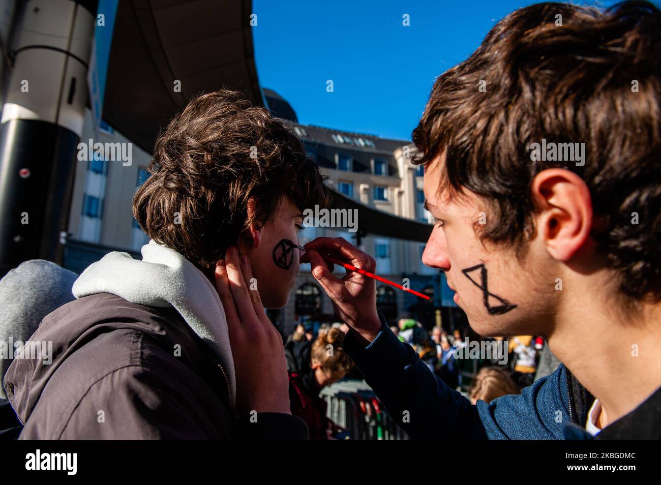 An XR activist is painting the XR logo on the face of another activist, during the School Strike for the Oceans, in Brussels, on February 7th, 2020. (Photo by Romy Arroyo Fernandez/NurPhoto) Stock Photo