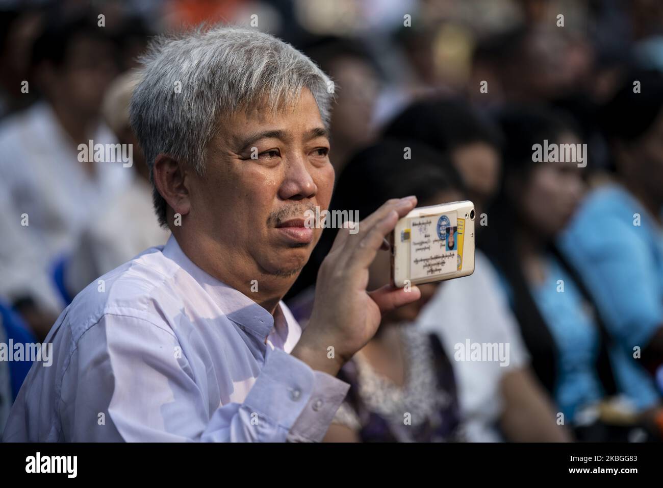 A man records a video with his mobile phone during a public meeting in Yangon on February 8, 2020. (Photo by Shwe Paw Mya Tin/NurPhoto) Stock Photo