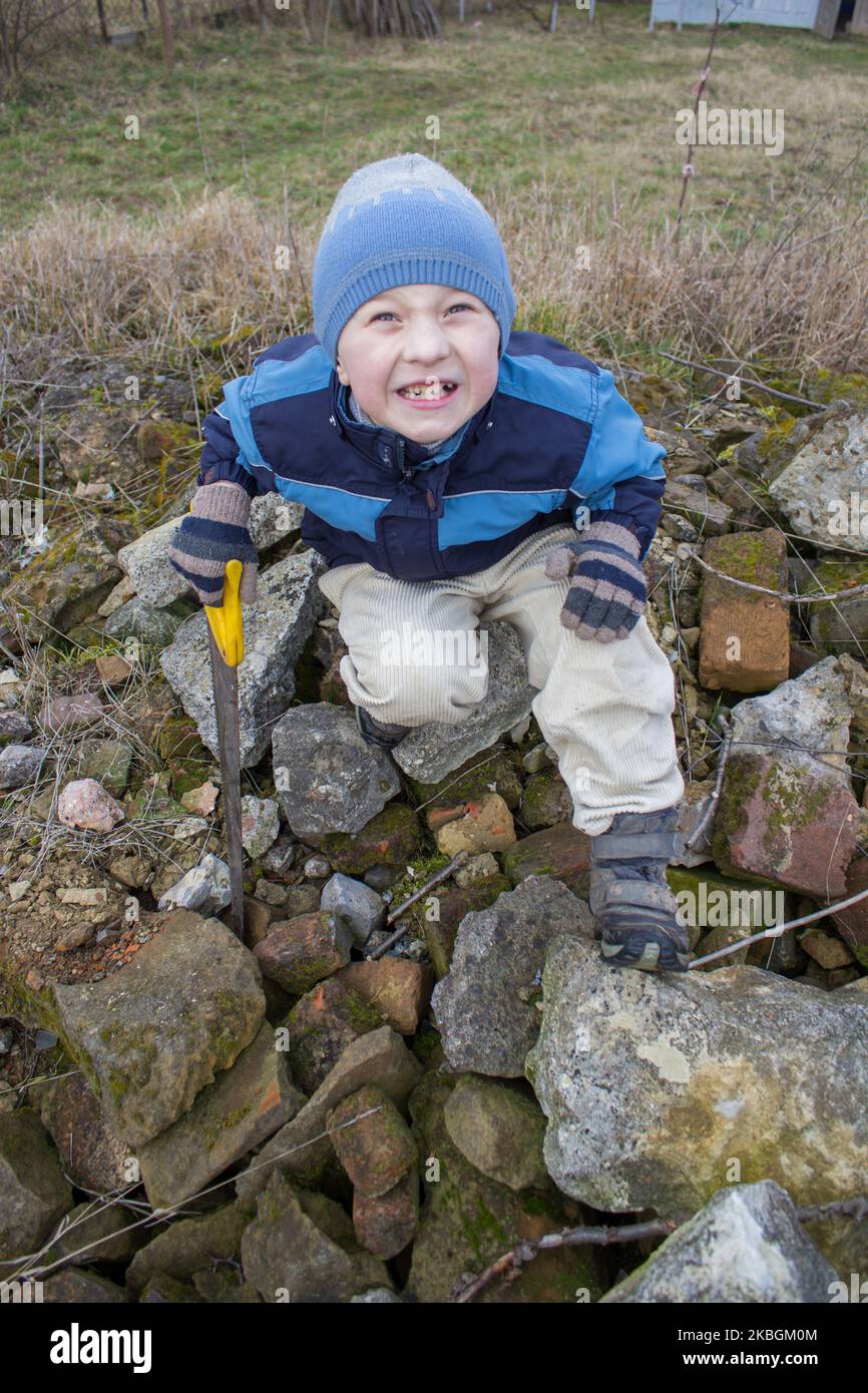 small boy sitting on a pile of stones Stock Photo