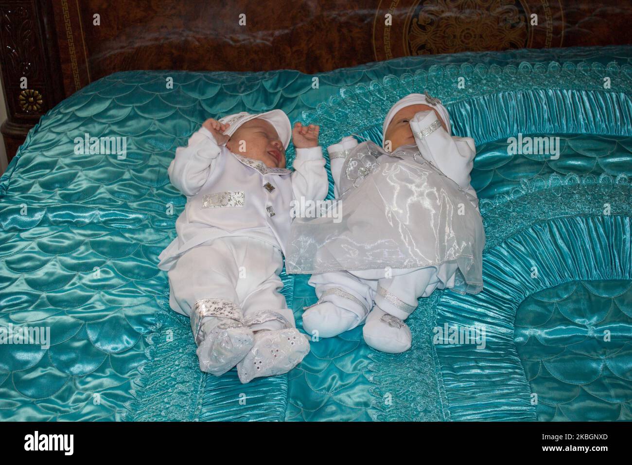 Newborn beautiful baby twins awake looking at each other in their cot