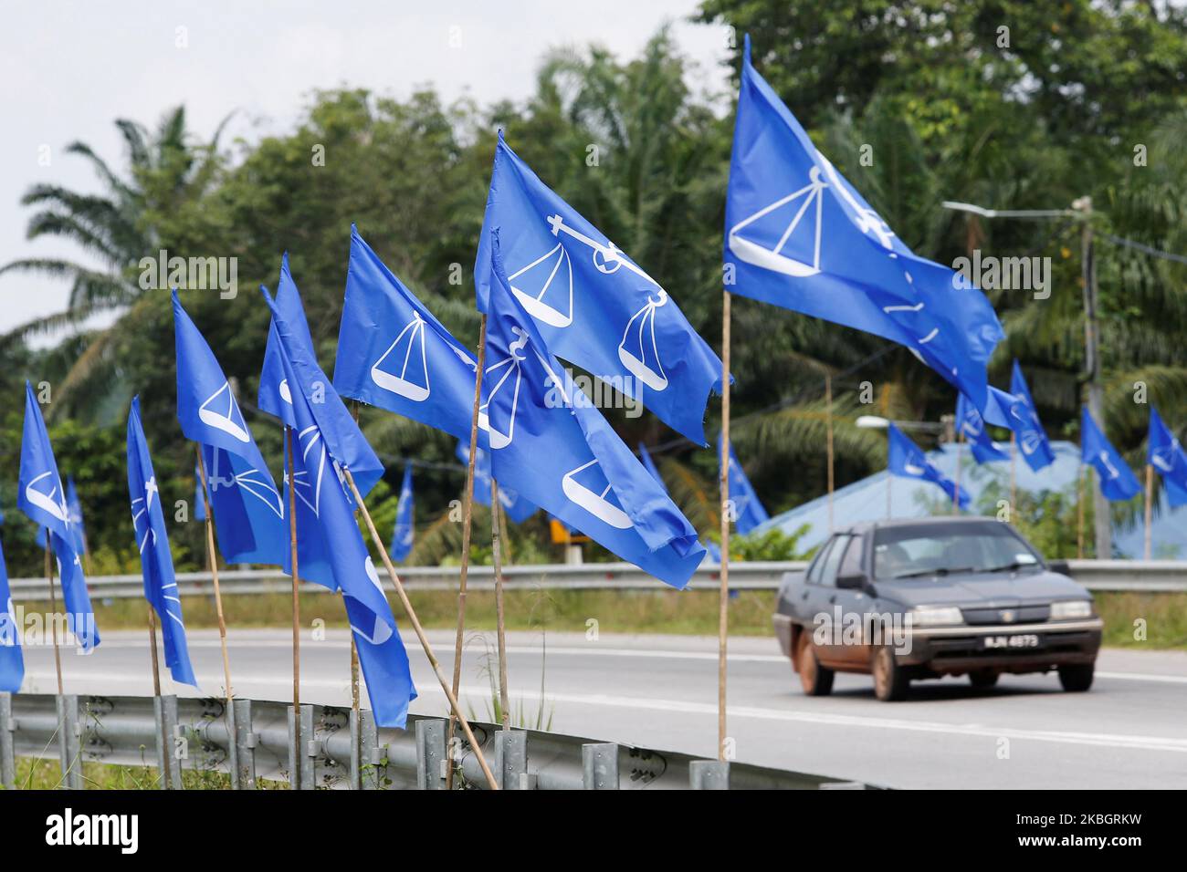 A car is seen behind flags of National Front coalition ahead of the upcoming 15th general election, in Bera, Pahang, Malaysia November 4, 2022. REUTERS/Lai Seng Sin Stock Photo
