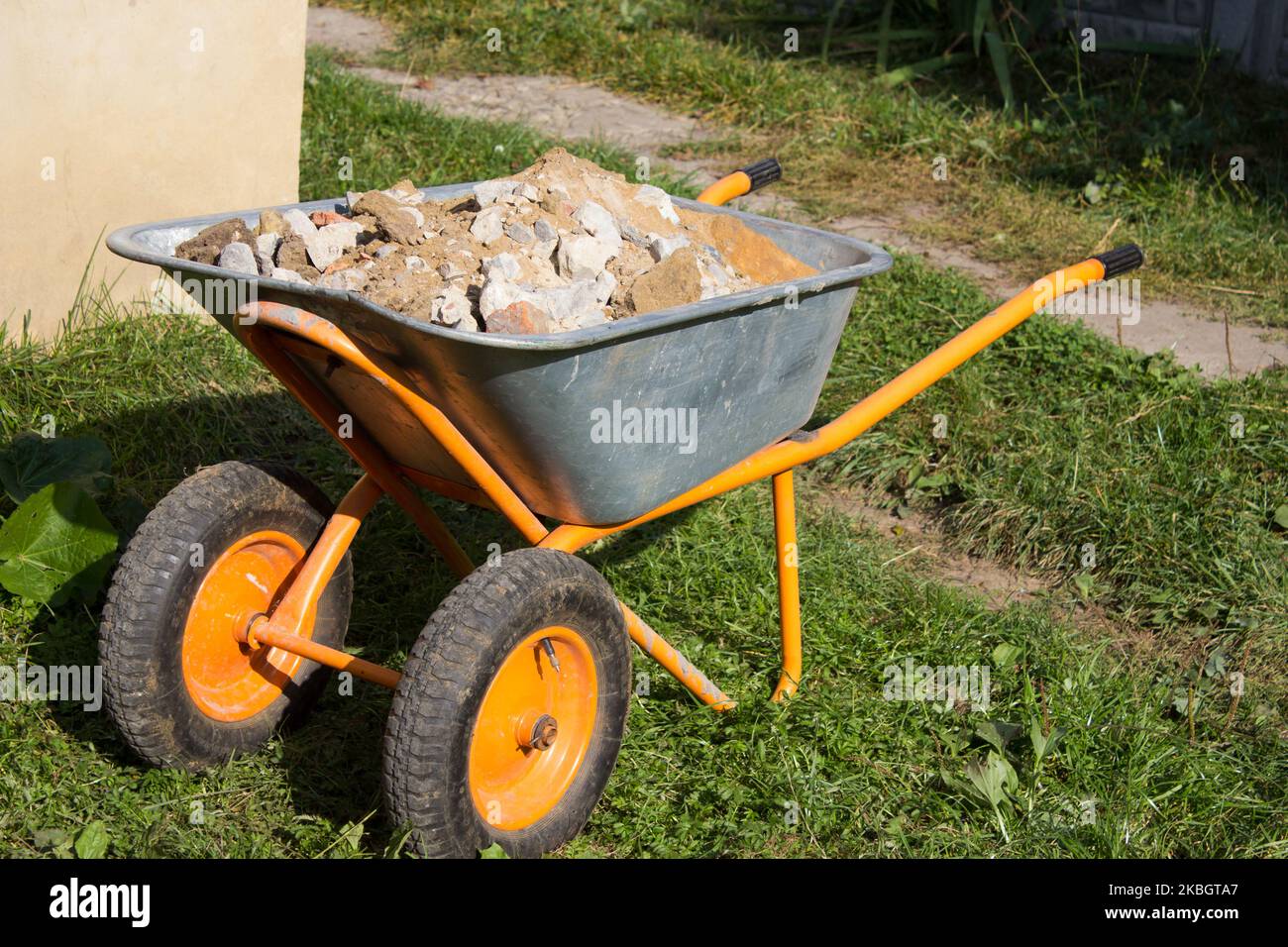 Wheelbarrow construction with rubbish waste in the yard Stock Photo Alamy