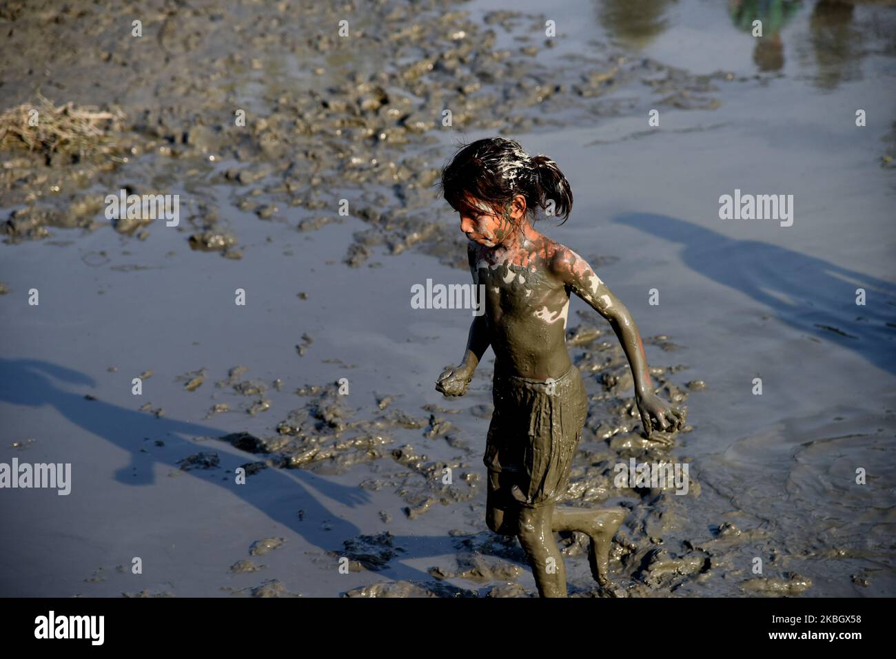 A group of Bangladeshi village children search for fish in a mud-bank of a canal Savar outskirts of Dhaka, Bangladesh, on February 13, 2020.The fisheries industry is a major source of protein for Bangladeshis with a large and rapidly growing number of people in Bangladesh depending on fishing for nutrition and income. (Photo by Mamunur Rashid/NurPhoto) Stock Photo