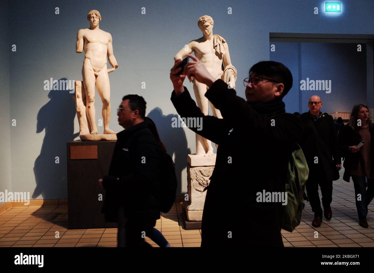 Visitors walk past statues in the Greek and Roman section of the British Museum in London, England, on February 13, 2020. The museum, one of London's top tourist attractions, is rarely far from controversy, from its long-running refusal to comply with Greek wishes for repatriation of the Parthenon Sculptures (otherwise known as the Parthenon or Elgin Marbles), to other debates on restitution over artifacts including the Rosetta Stone (taken from Egypt) and Benin bronzes (taken from what is now Nigeria), to more recent pressure from climate activists over the institution's sponsorship ties to o Stock Photo