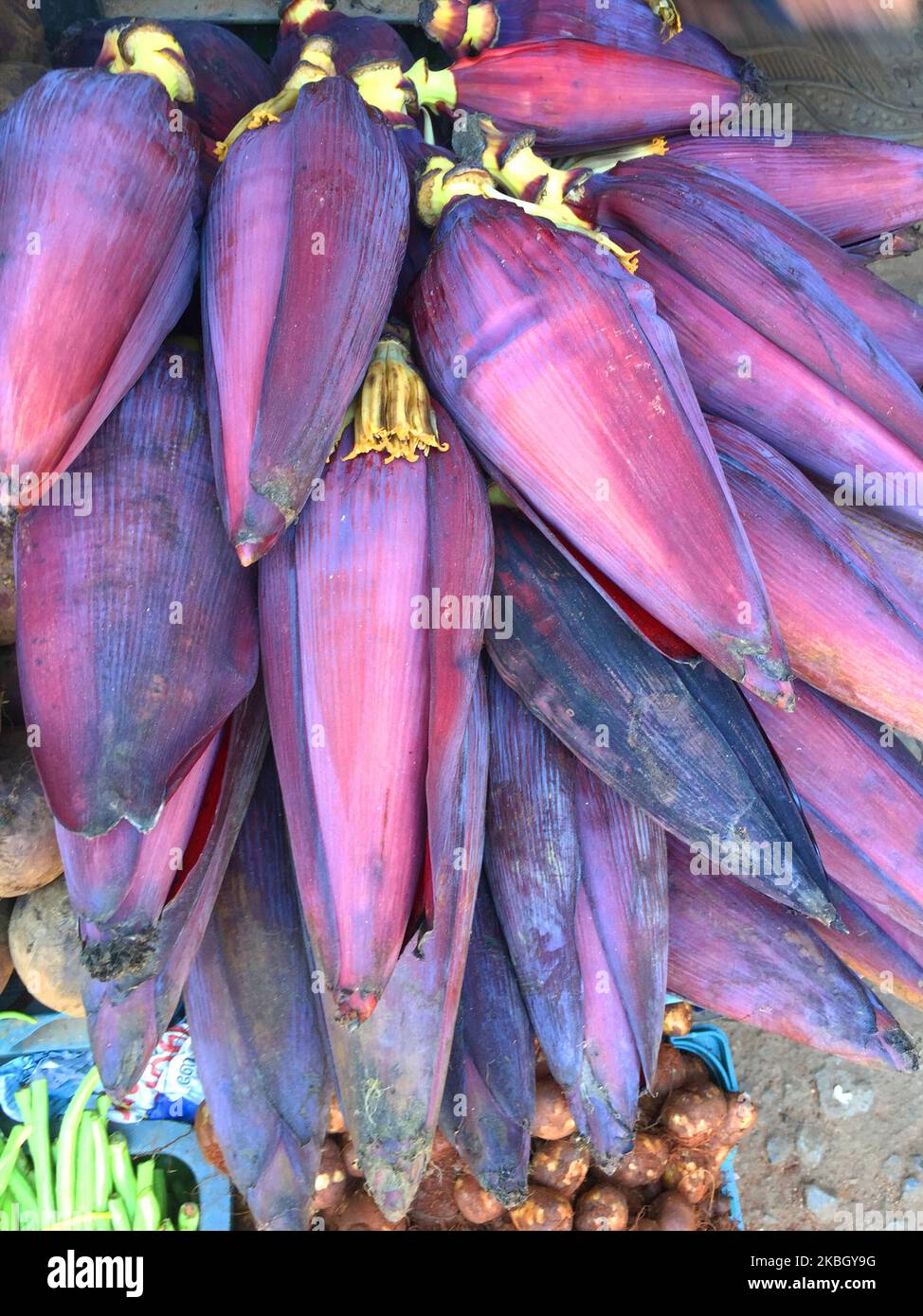 Banana plant flowers for sale at a produce market in Ambalmkulam