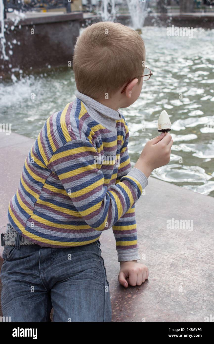 boy looks at the fountain turned away in the first place Stock Photo