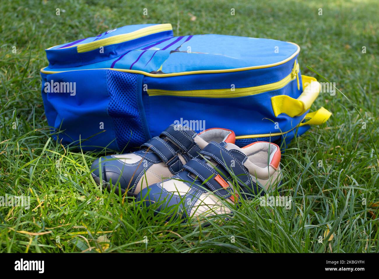 school backpack with sneakers on the grass lay Stock Photo