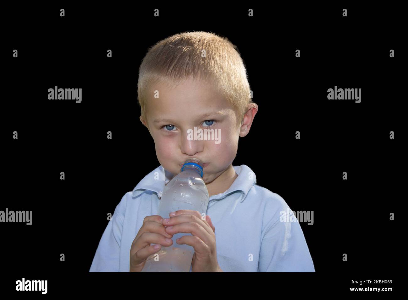 Boy holding a water bottle in his mouth and blowing Stock Photo Alamy