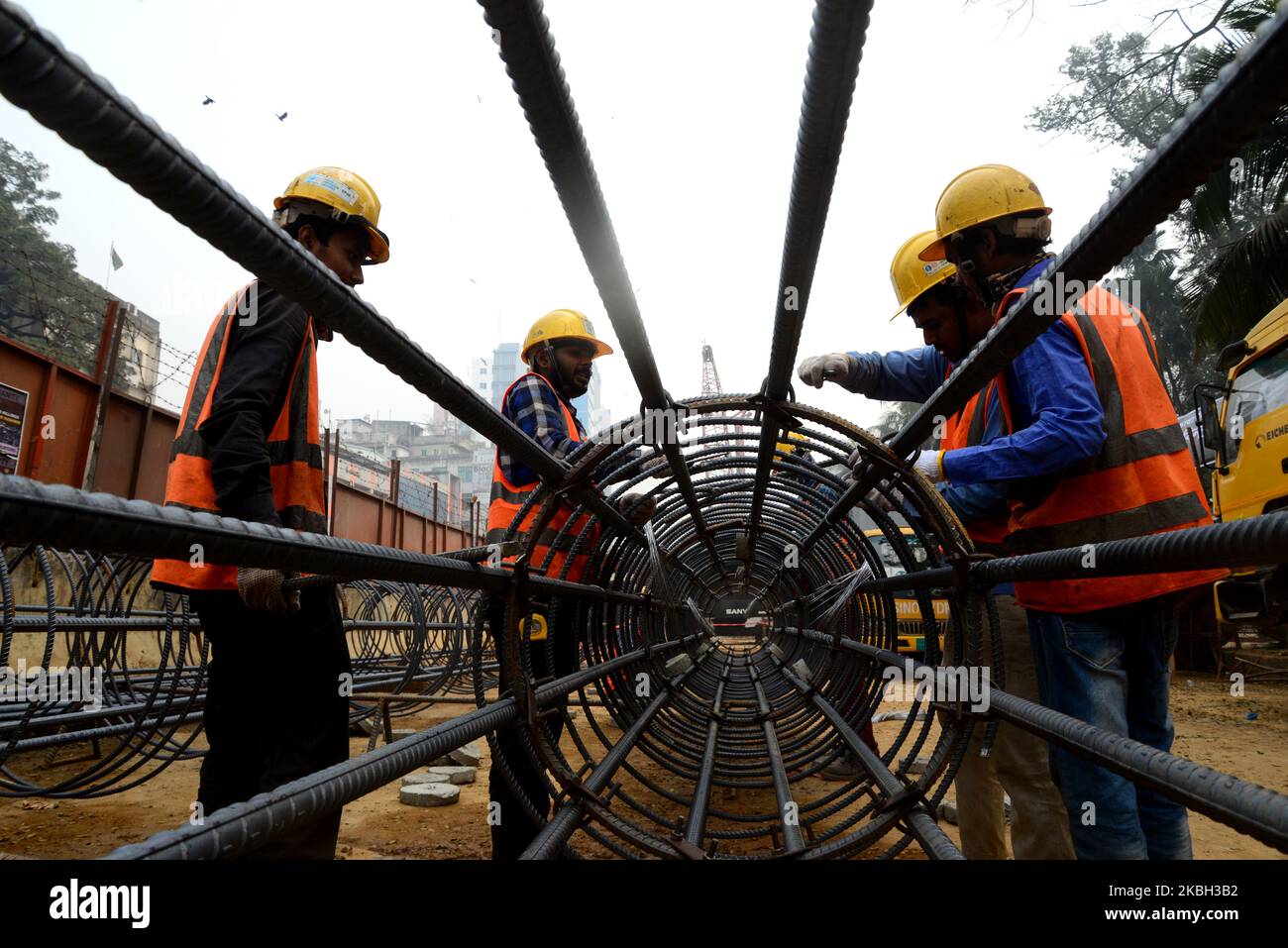 Bangladeshi workers preparing reinforcing steel at a construction site