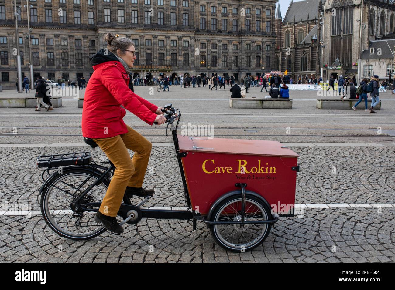 People using bikes in the city and/or electric car charging stations in Amsterdam seen on February 17, 2019. Amsterdam is equipped with an wide network of cycle-paths, so safe and comfortable that even toddlers and elderly people use bikes as the easiest mode of transport. Bikes are commonly used in other cities such as The Hague and Rotterdam. Gasoline and diesel fueled cars and motorcycles will be banned from Amsterdam from 2030 in an effort to clean up the city's air, the Dutch capital's council said in 2019. The use of electric vehicles is increasing in the city. A pass is needed to charge Stock Photo