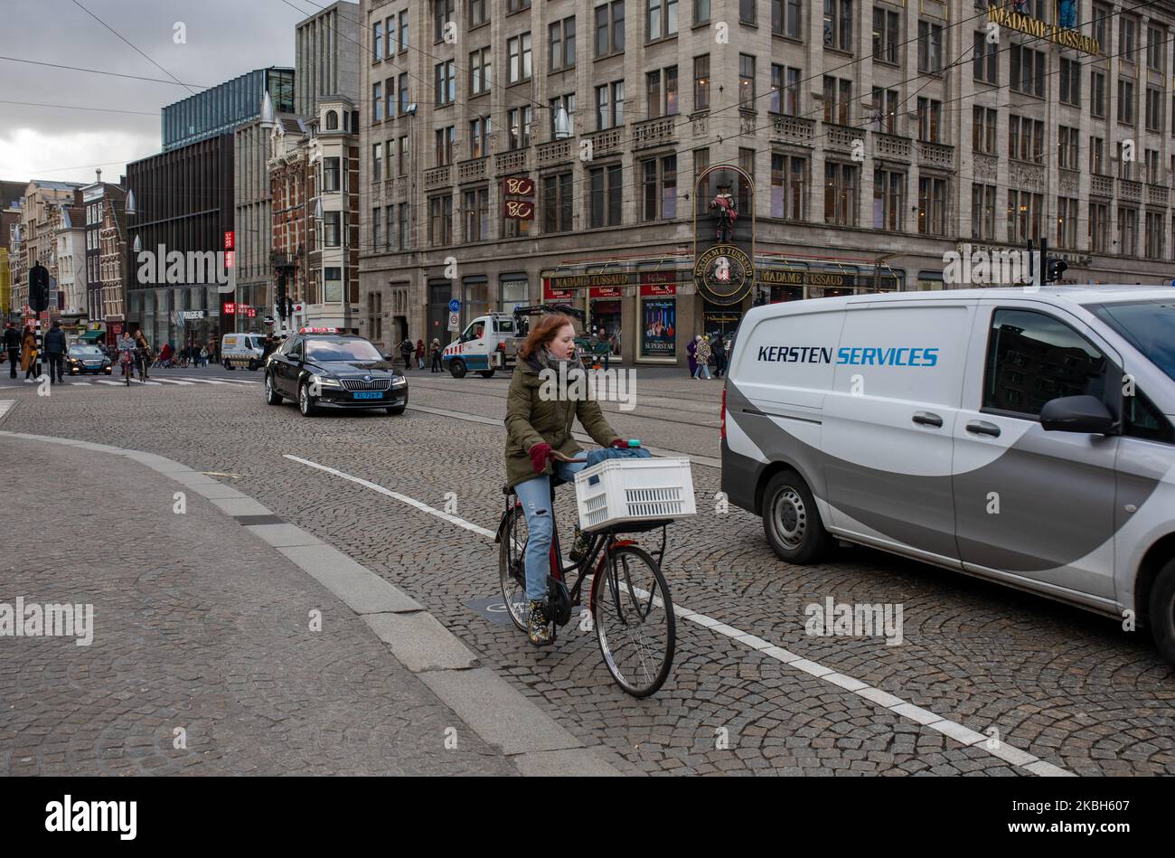 People using bikes in the city and/or electric car charging stations in Amsterdam seen on February 17, 2019. Amsterdam is equipped with an wide network of cycle-paths, so safe and comfortable that even toddlers and elderly people use bikes as the easiest mode of transport. Bikes are commonly used in other cities such as The Hague and Rotterdam. Gasoline and diesel fueled cars and motorcycles will be banned from Amsterdam from 2030 in an effort to clean up the city's air, the Dutch capital's council said in 2019. The use of electric vehicles is increasing in the city. A pass is needed to charge Stock Photo
