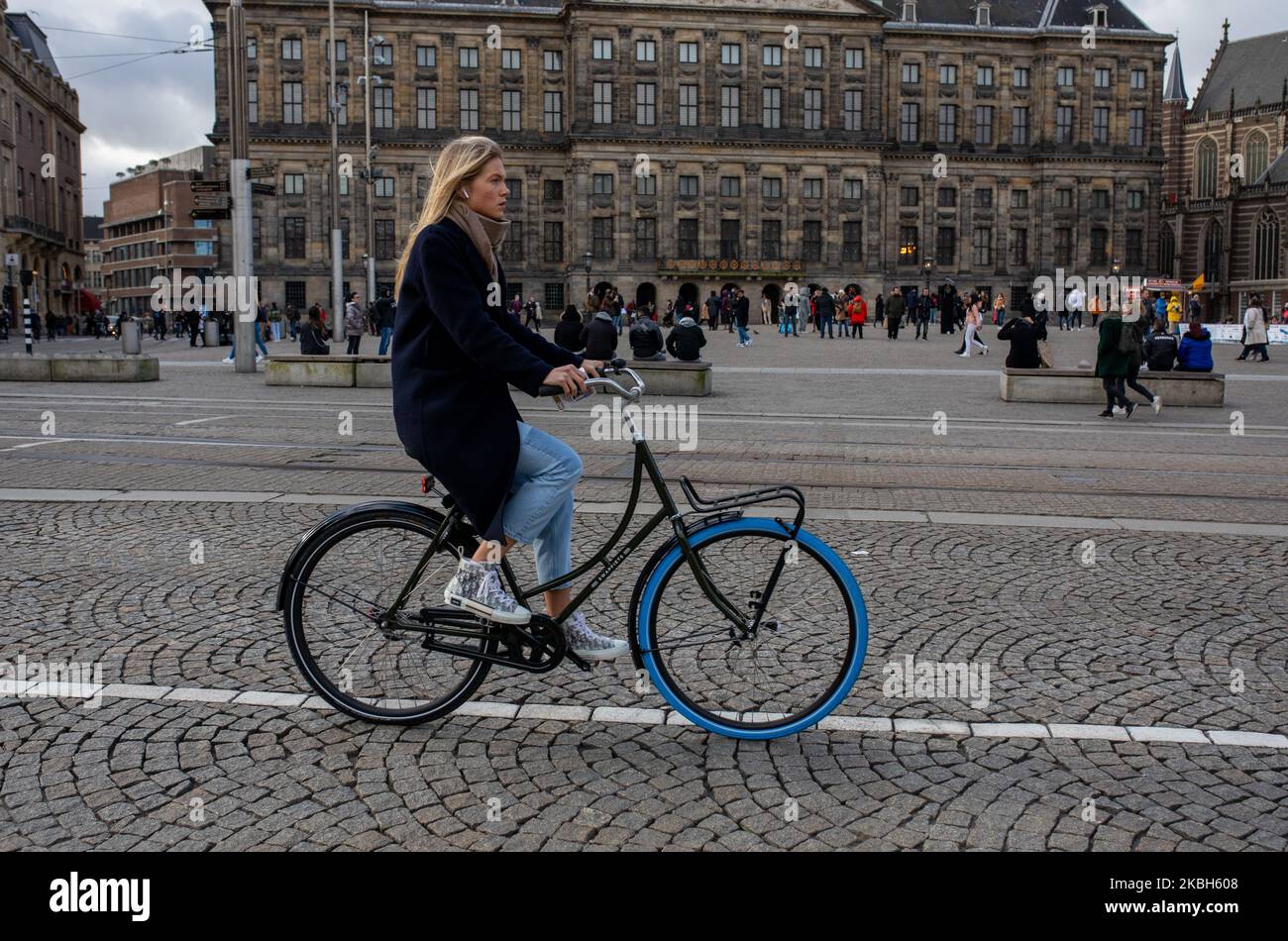 People using bikes in the city and/or electric car charging stations in Amsterdam seen on February 17, 2019. Amsterdam is equipped with an wide network of cycle-paths, so safe and comfortable that even toddlers and elderly people use bikes as the easiest mode of transport. Bikes are commonly used in other cities such as The Hague and Rotterdam. Gasoline and diesel fueled cars and motorcycles will be banned from Amsterdam from 2030 in an effort to clean up the city's air, the Dutch capital's council said in 2019. The use of electric vehicles is increasing in the city. A pass is needed to charge Stock Photo