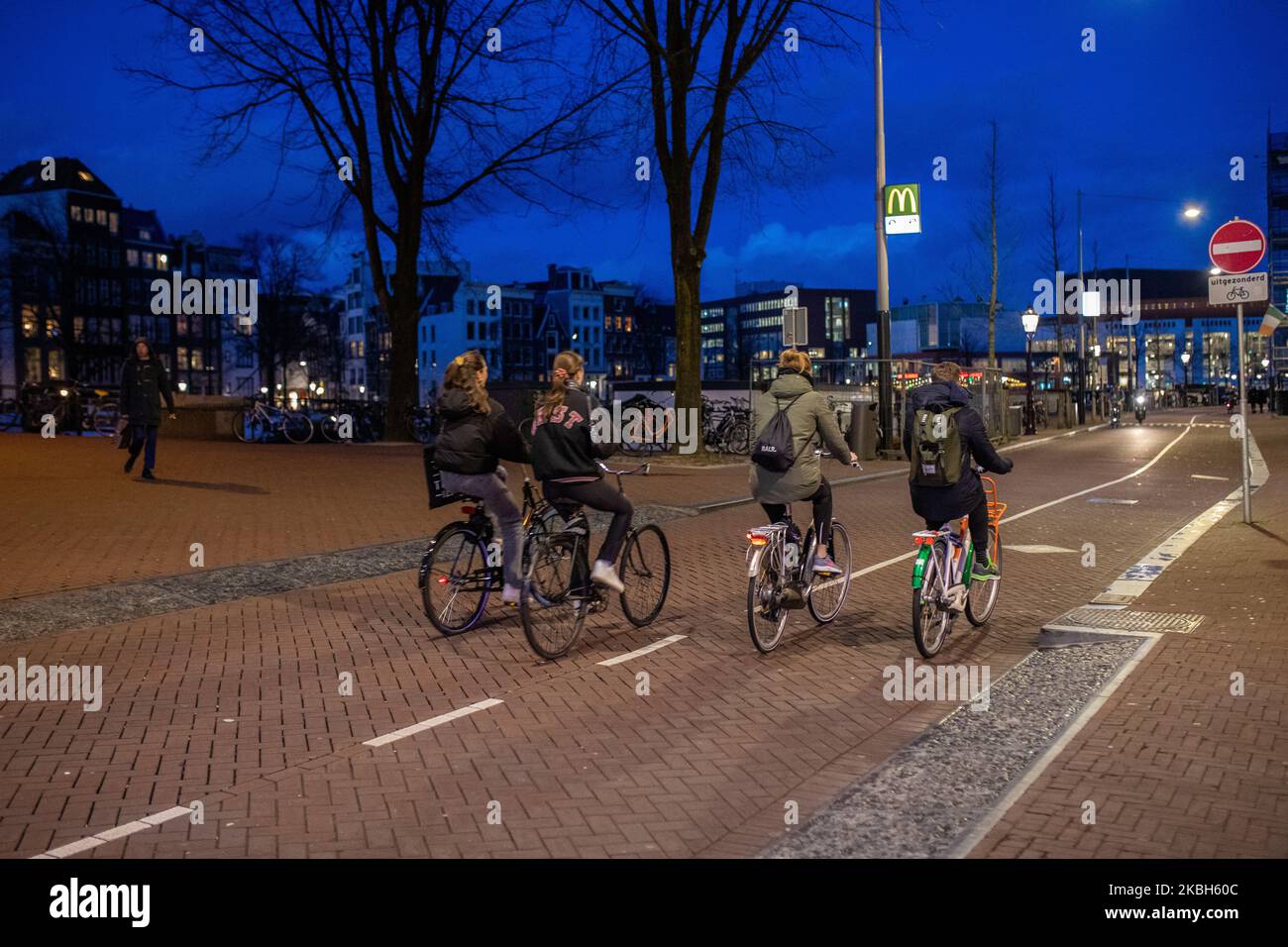 People using bikes in the city and/or electric car charging stations in Amsterdam seen on February 17, 2019. Amsterdam is equipped with an wide network of cycle-paths, so safe and comfortable that even toddlers and elderly people use bikes as the easiest mode of transport. Bikes are commonly used in other cities such as The Hague and Rotterdam. Gasoline and diesel fueled cars and motorcycles will be banned from Amsterdam from 2030 in an effort to clean up the city's air, the Dutch capital's council said in 2019. The use of electric vehicles is increasing in the city. A pass is needed to charge Stock Photo