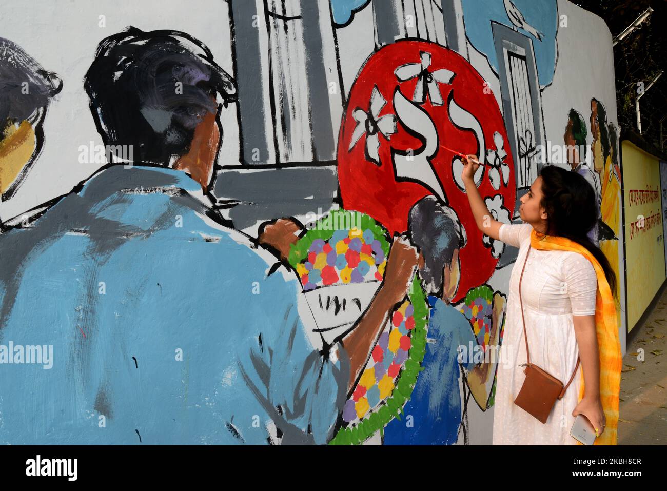 Bangladeshi fine arts students paint on a wall in front of the Central Shahid Minar, (Language