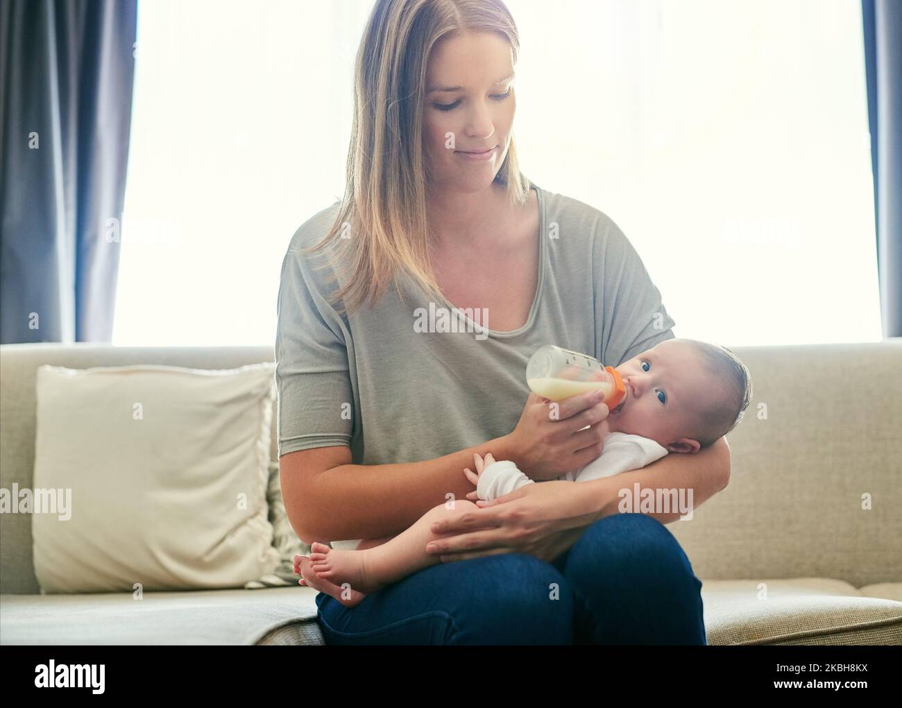 I handle her with complete care. a young mother and her baby at home. Stock Photo