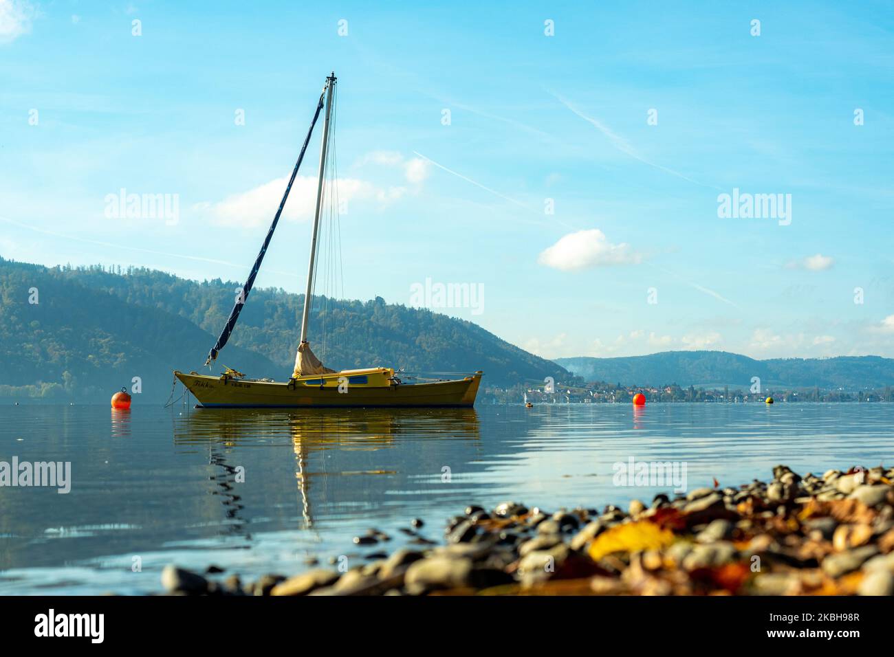 Portrait of a single anchored sailboat in Lake Constance in autumn near Sipplingen Stock Photo