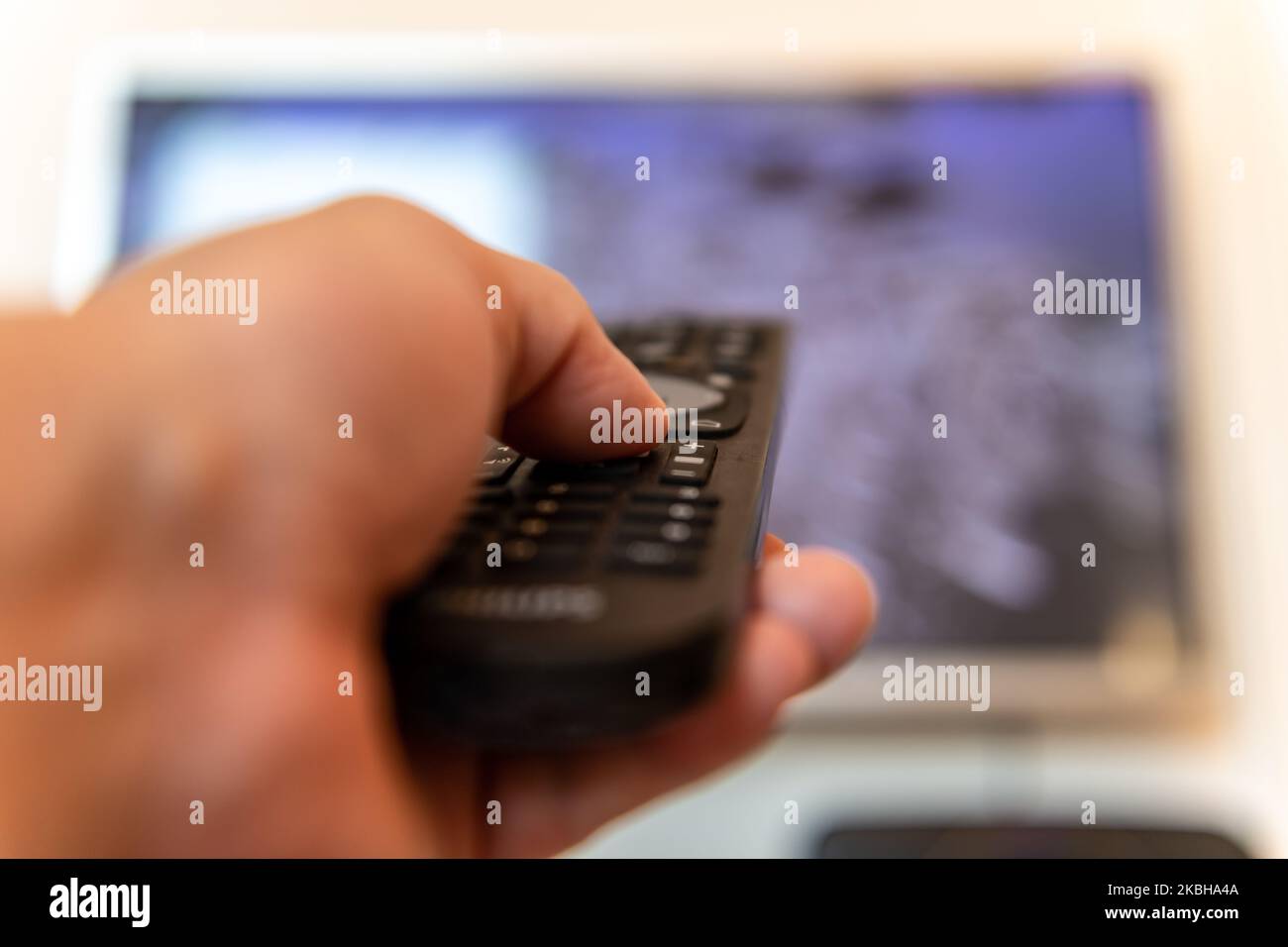 A person using the remote control of a television. Stock Photo