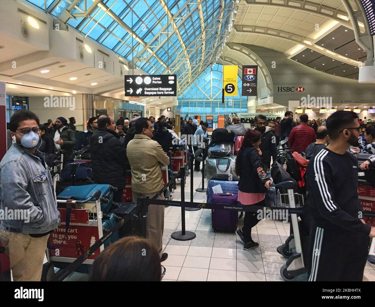 Crowd of passengers waiting to check-in for their flight at Pearson International Airport in Ontario, Canada. Some passangers are wearing masks to protect from the novel coronavirus (COVID-19). Pearson International Airport is Canada's largest and busiest airport. (Photo by Creative Touch Imaging Ltd./NurPhoto) Stock Photo