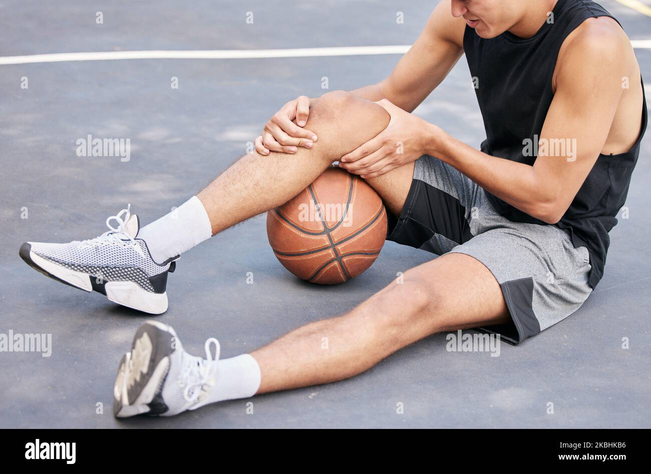 Basketball, man and knee in sports injury on the court holding painful, sore or tender area in