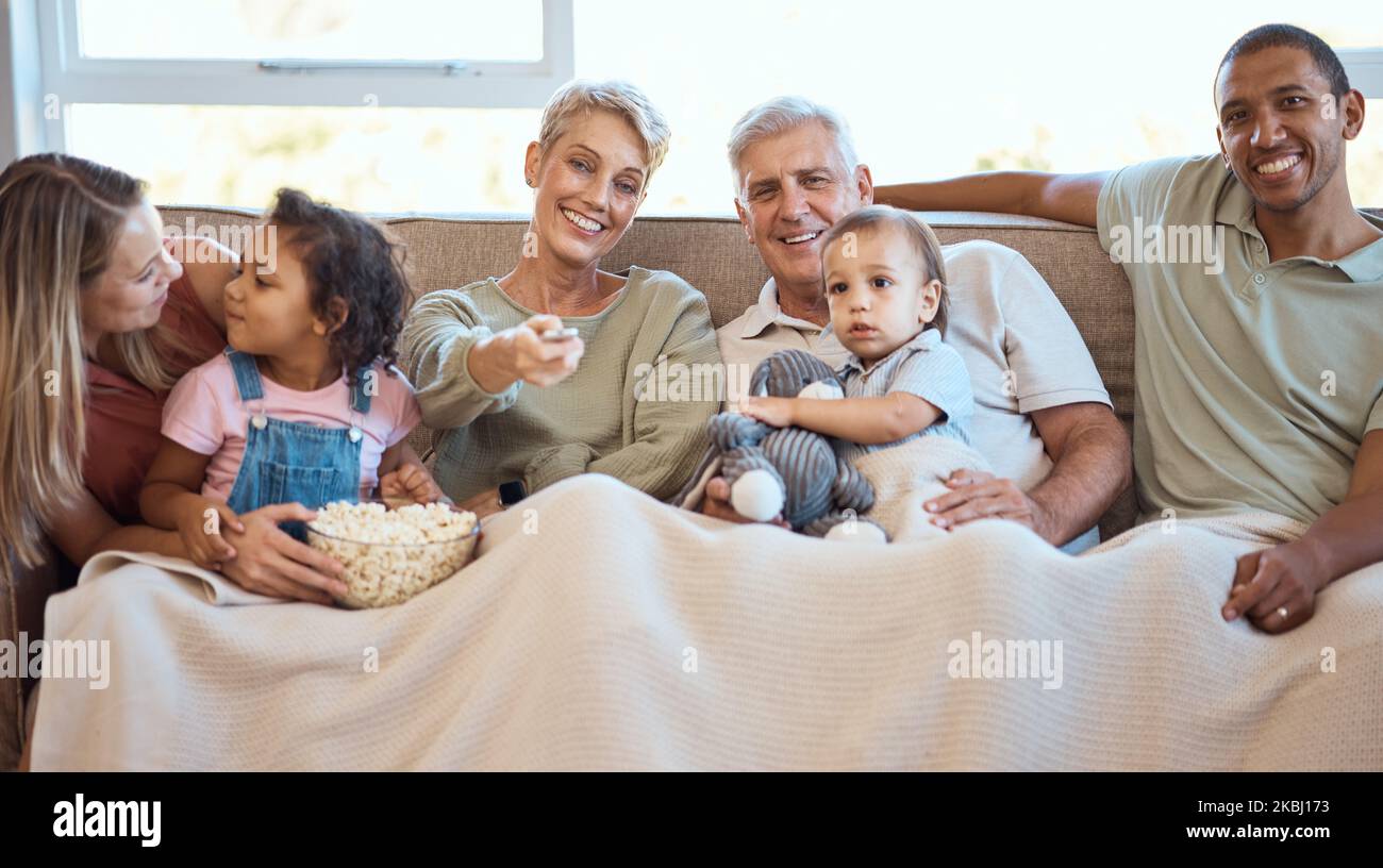 Happy family on sofa watching tv with popcorn and kids show, film or comedy movie on live streaming service. Television, relax and grandparents with Stock Photo