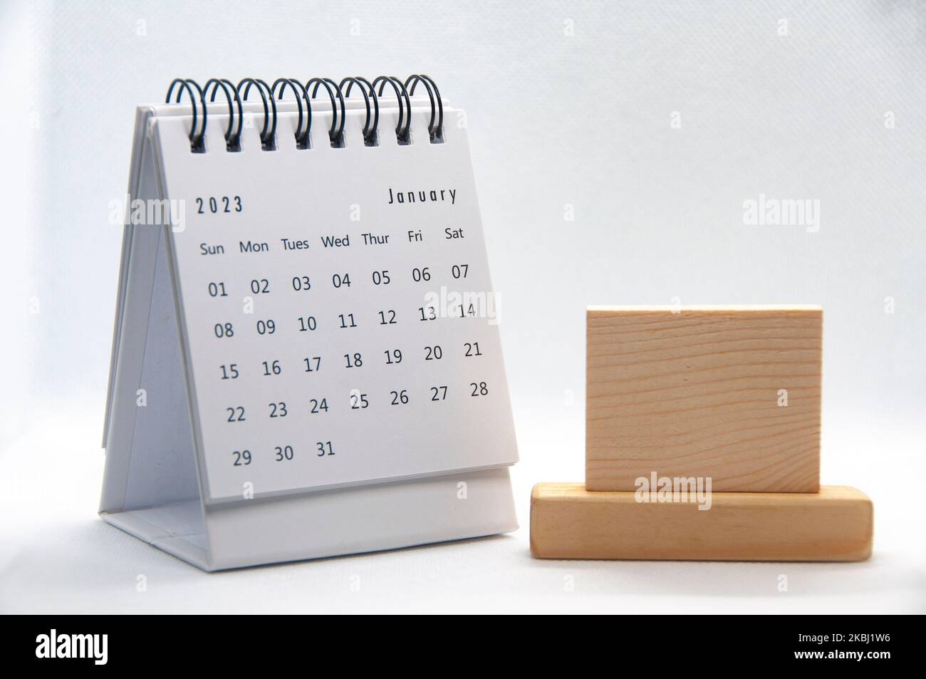 January 2023 white desk calendar on white background with customizable wooden space for text. Calendar concept. Stock Photo