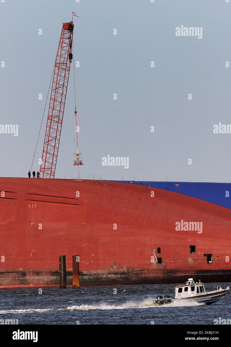 Salvage workers are seen standing on the Golden Ray cargo ship on