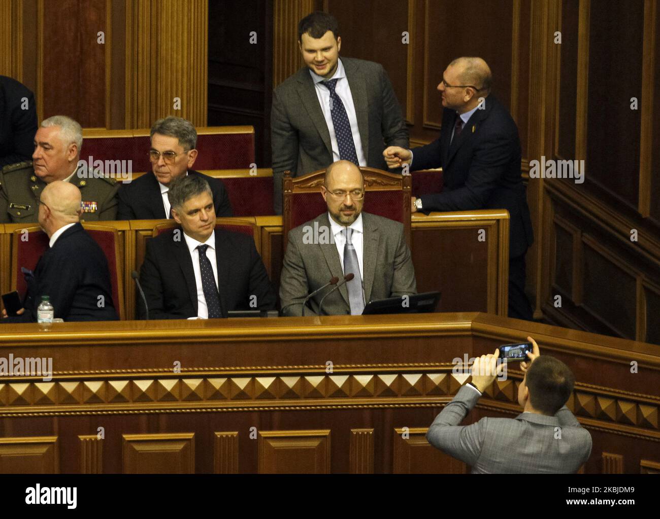 A lawmaker takes a photo on mobile phone of new apointed Ukrainian Prime Minister Denys Shmygal and members of the newly appointed Cabinet of Ministers react during a session of Ukrainian Parliament, in Kyiv, Ukraine, on 04 March, 2020. Ukrainian Parliament voited for appointment of new Ukraine's Prime minister and newly the Cabinet of Ministers. (Photo by STR/NurPhoto) Stock Photo