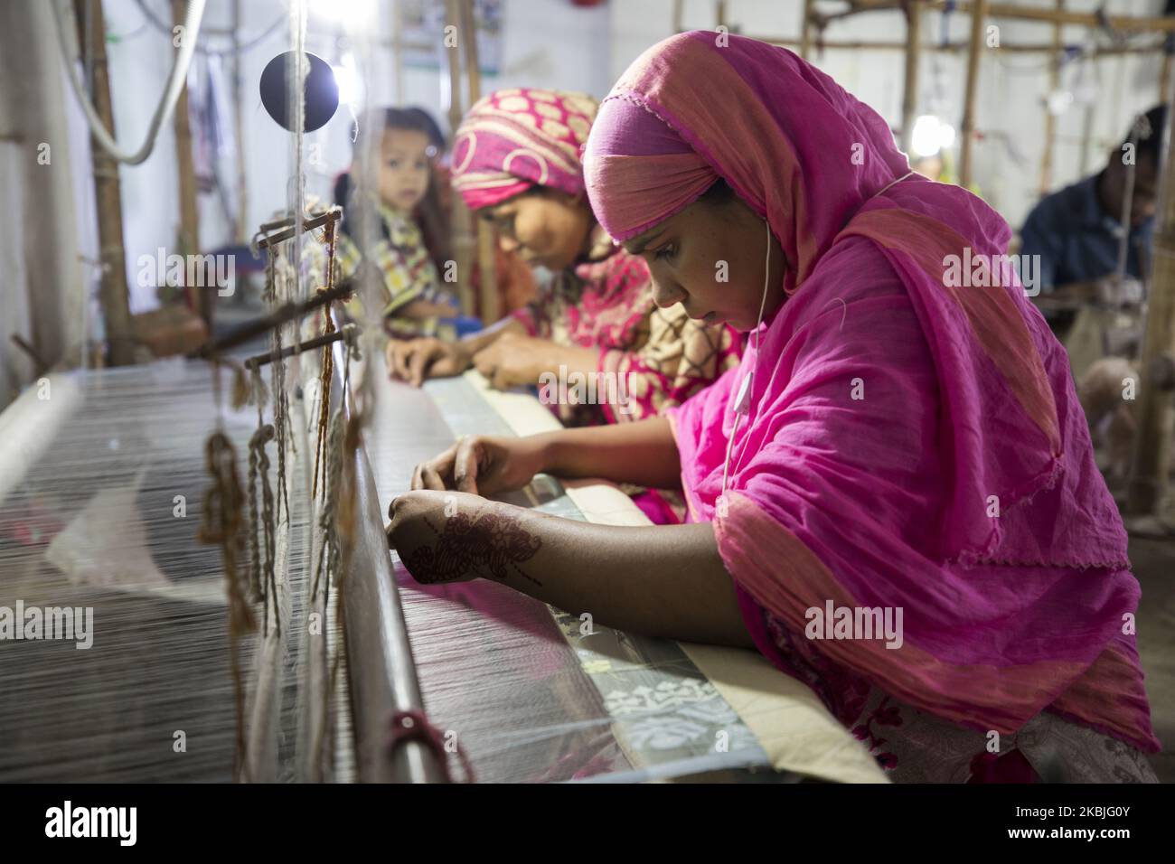 Handloom weaver weaves Jamdani saree on a traditional wooden hand weaving loom at Demra Jamdani Palli, in Dhaka, Bangladesh on March 06, 2020. (Photo by Ahmed Salahuddin/NurPhoto) Stock Photo