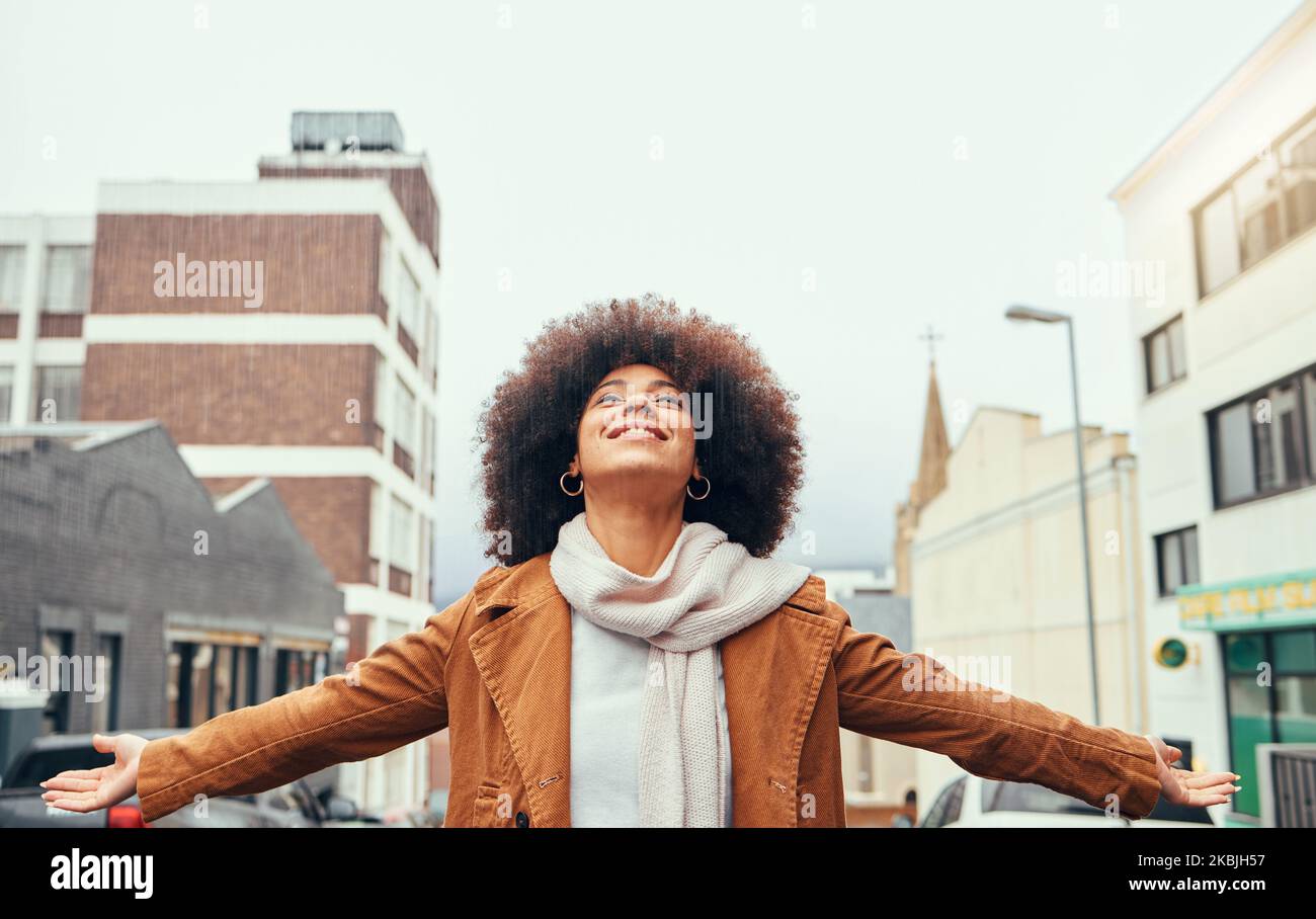 Black woman afro, freedom and love in the city for travel, tourism or vacation with smile in the outdoors. Happy African American female embracing Stock Photo