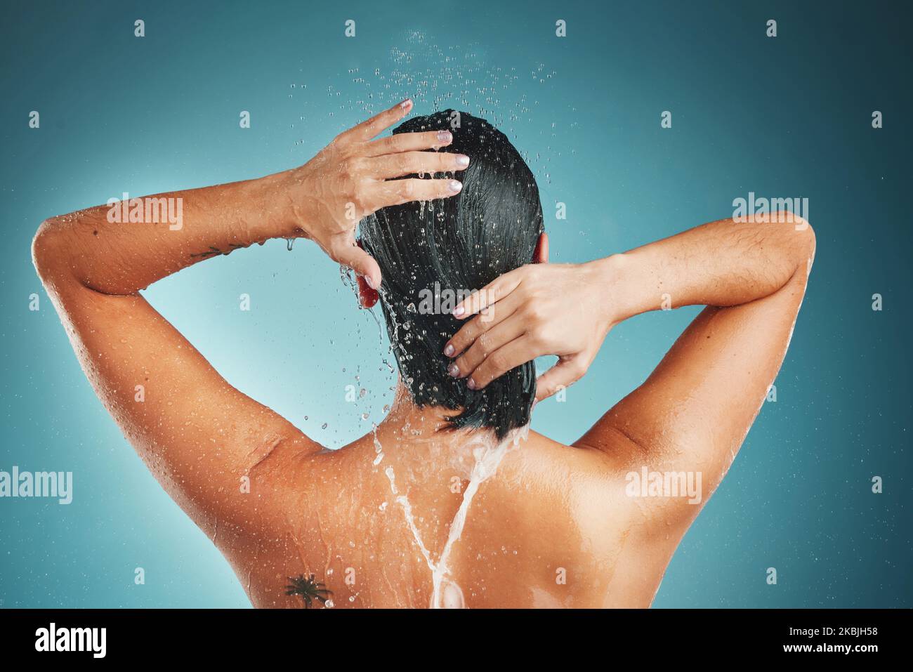 Hair, water splash and woman in shower for skincare, hygiene and beauty in a studio with mockup. Hands, hair care and girl cleaning, relax and Stock Photo