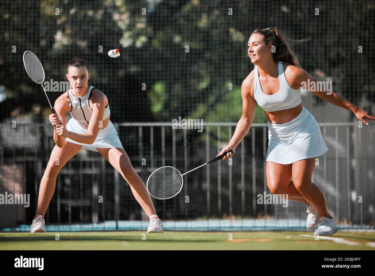 Fitness, team and women with tennis on tennis court, athlete playing game with focus and sport workout outdoor. Sports match, young and cardio while Stock Photo