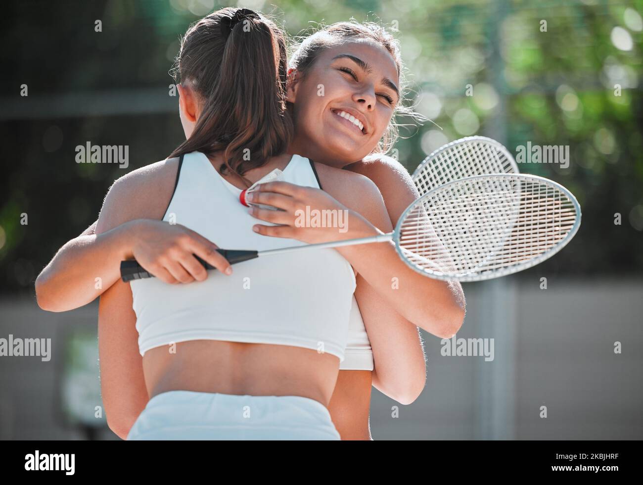 Badminton, happy and sports friends hug together for bond, love and care with smile on game break. Exercise, workout and happiness in women friendship Stock Photo
